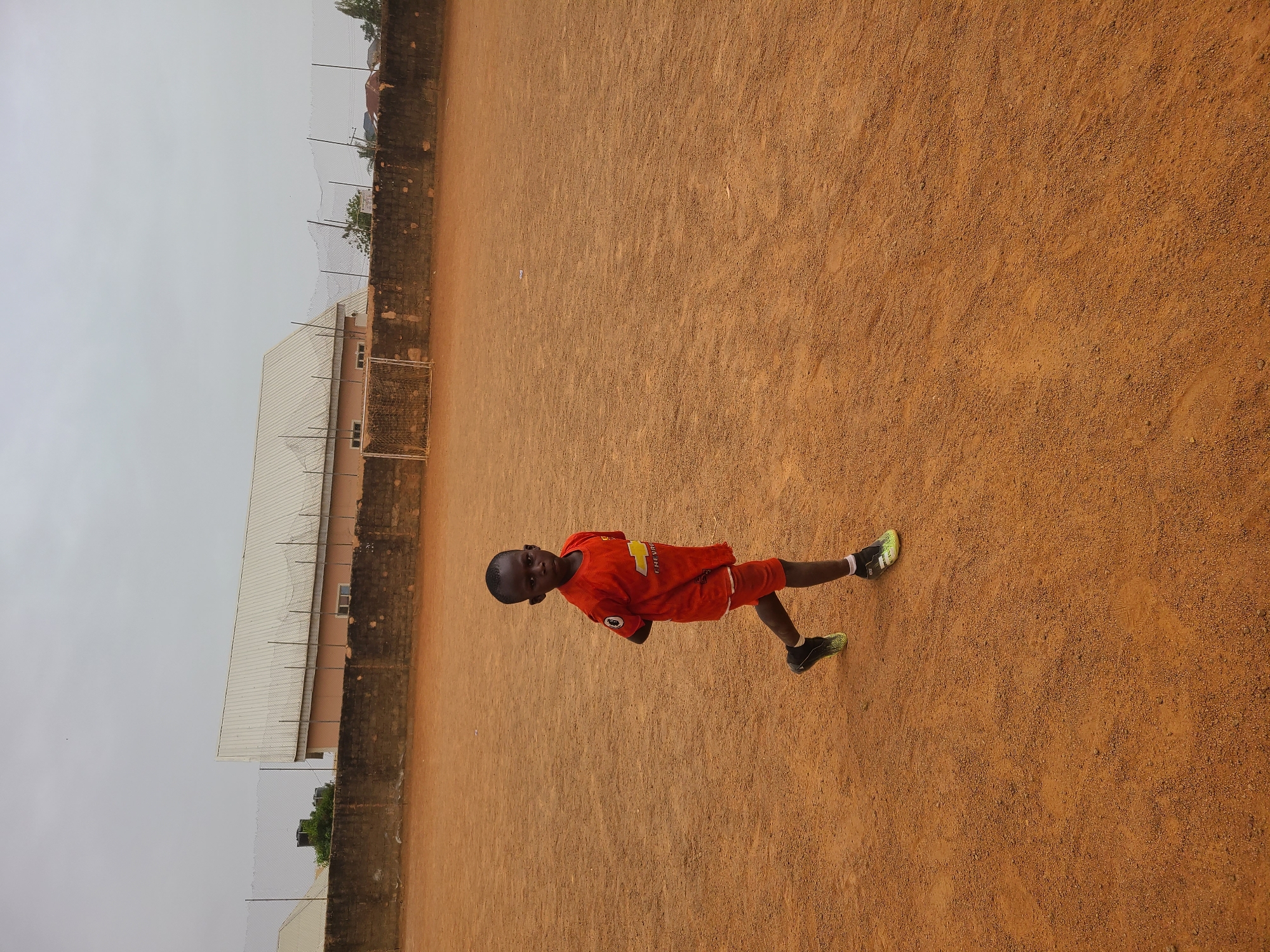 Young boys play soccer on dirt field in Nigeria