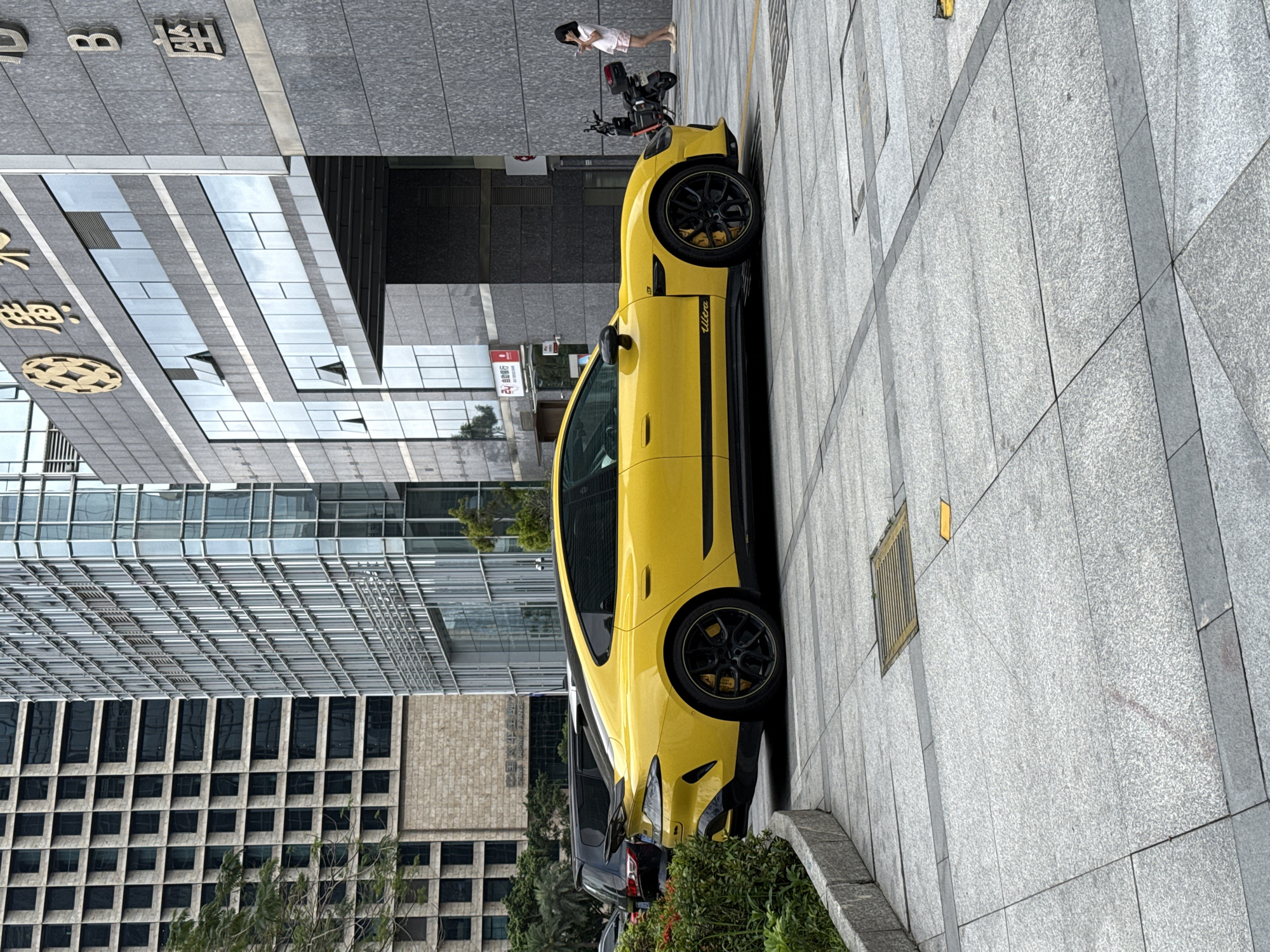 Yellow Porsche parked near modern buildings in Futian District