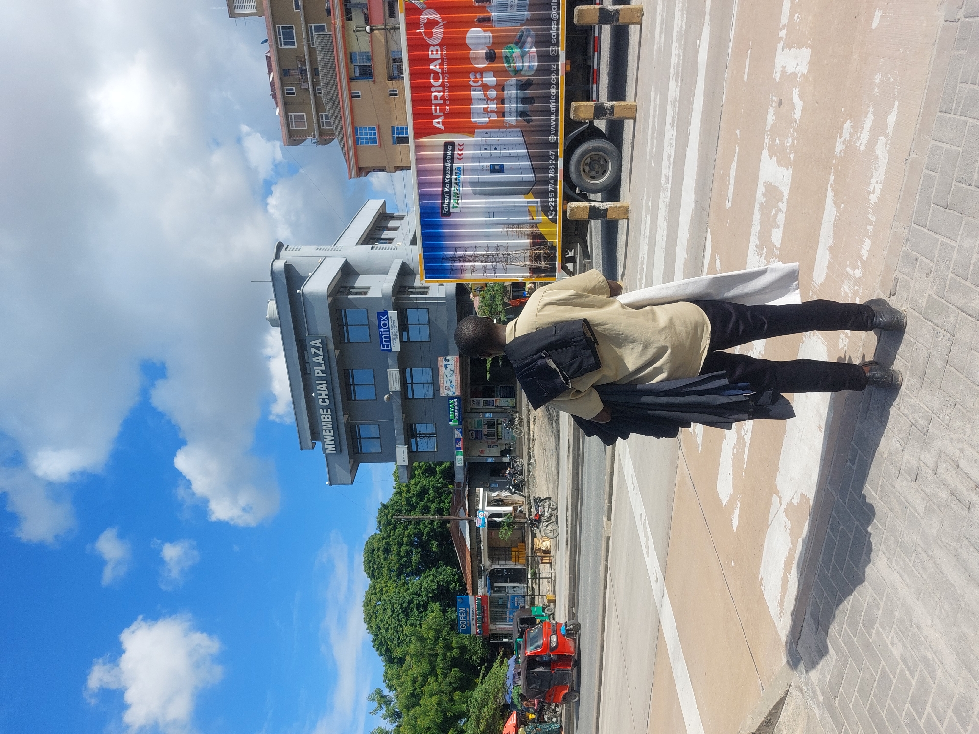 Midday street life observed across Dar es-Salaam crosswalks and sidewalks