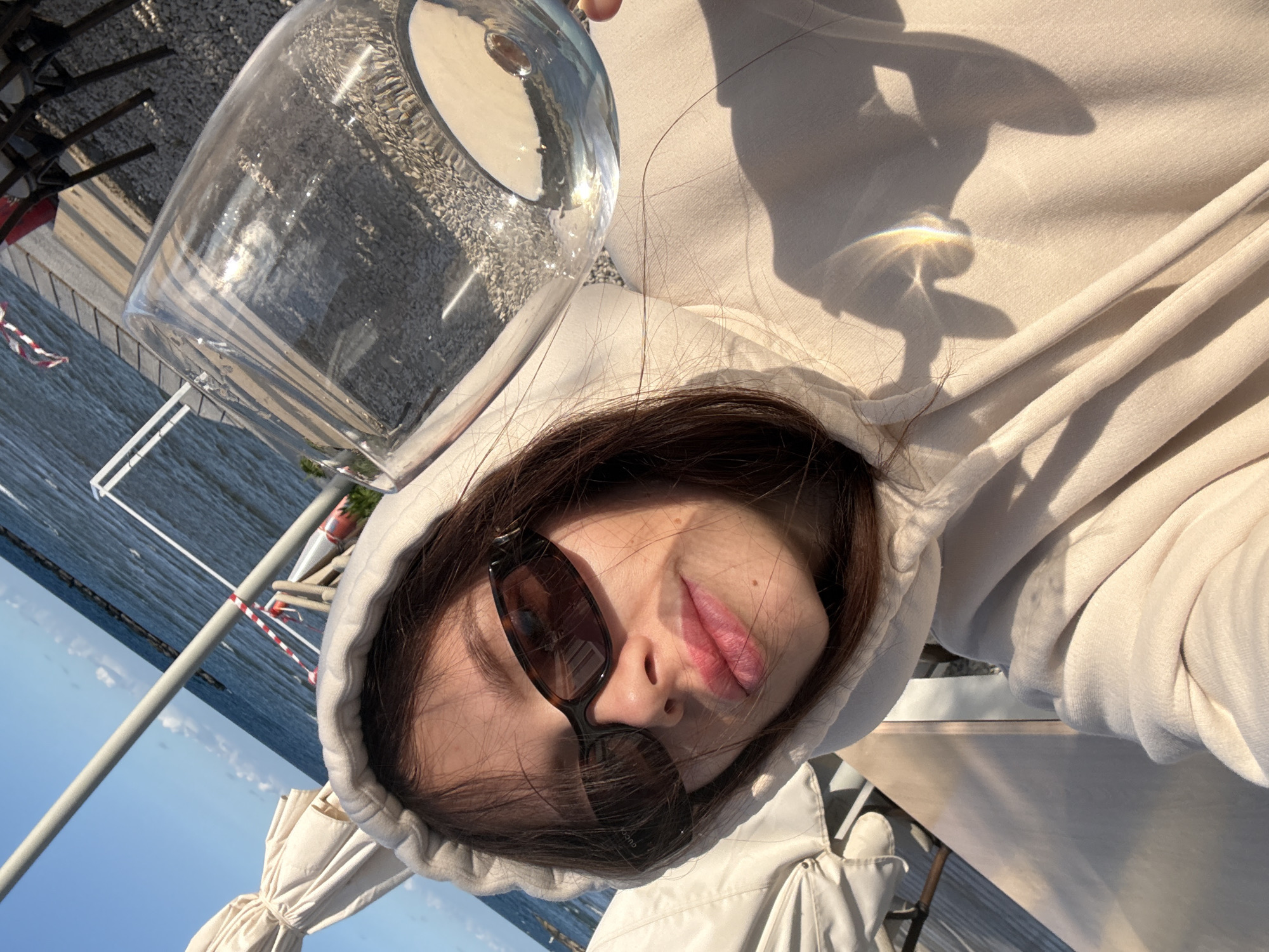 Woman enjoys drink by marina in Oroklini, Cyprus