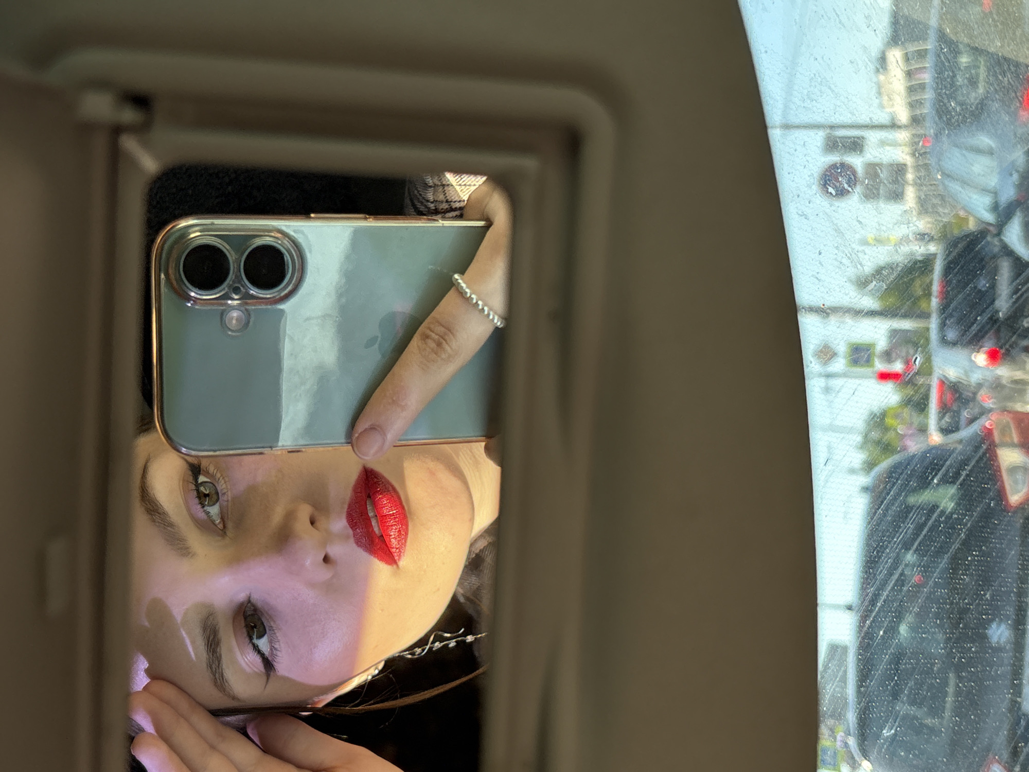 Woman touches up makeup in car mirror on Saint Petersburg street