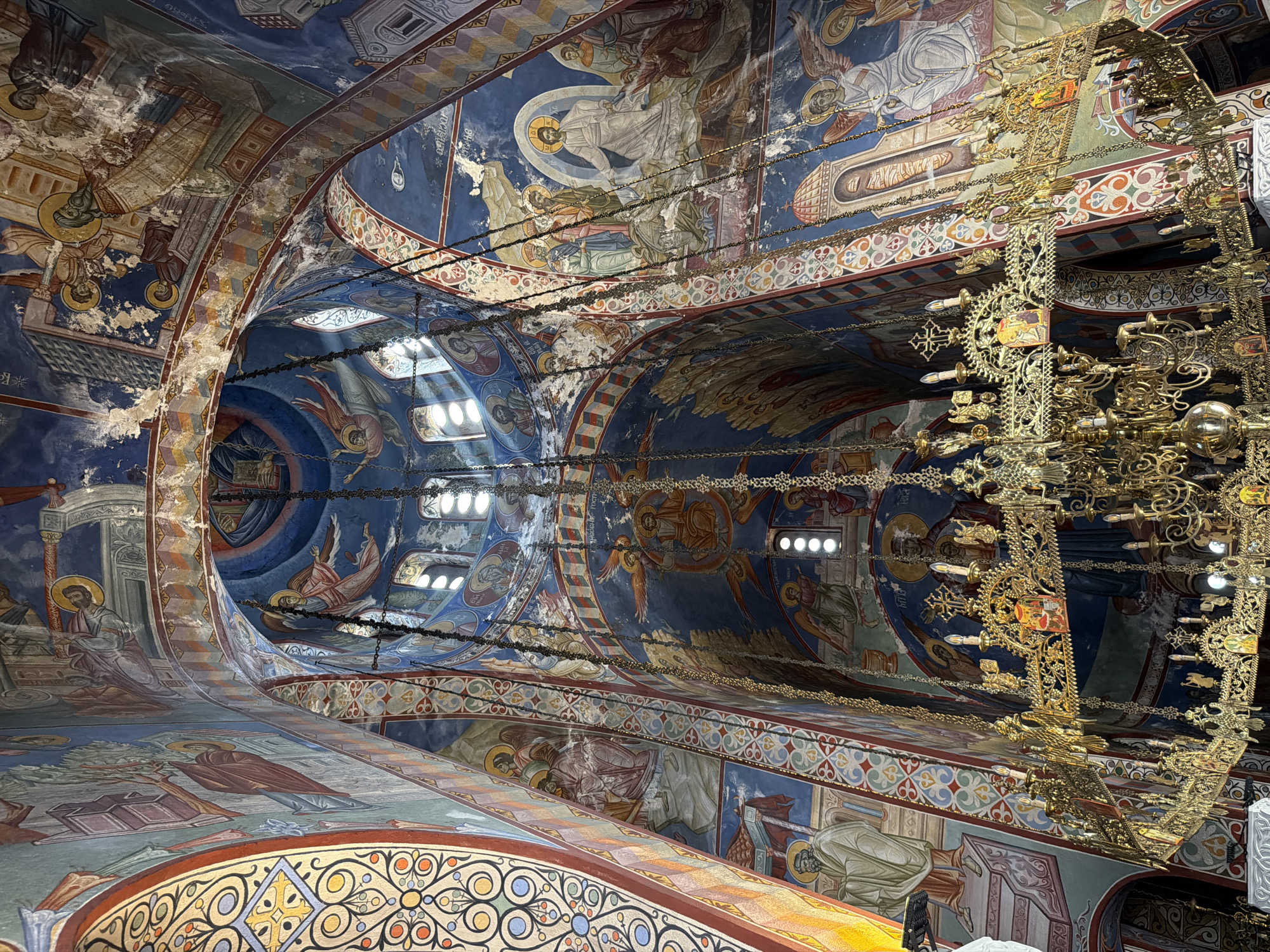 Orthodox church interior covered in vivid religious frescoes
