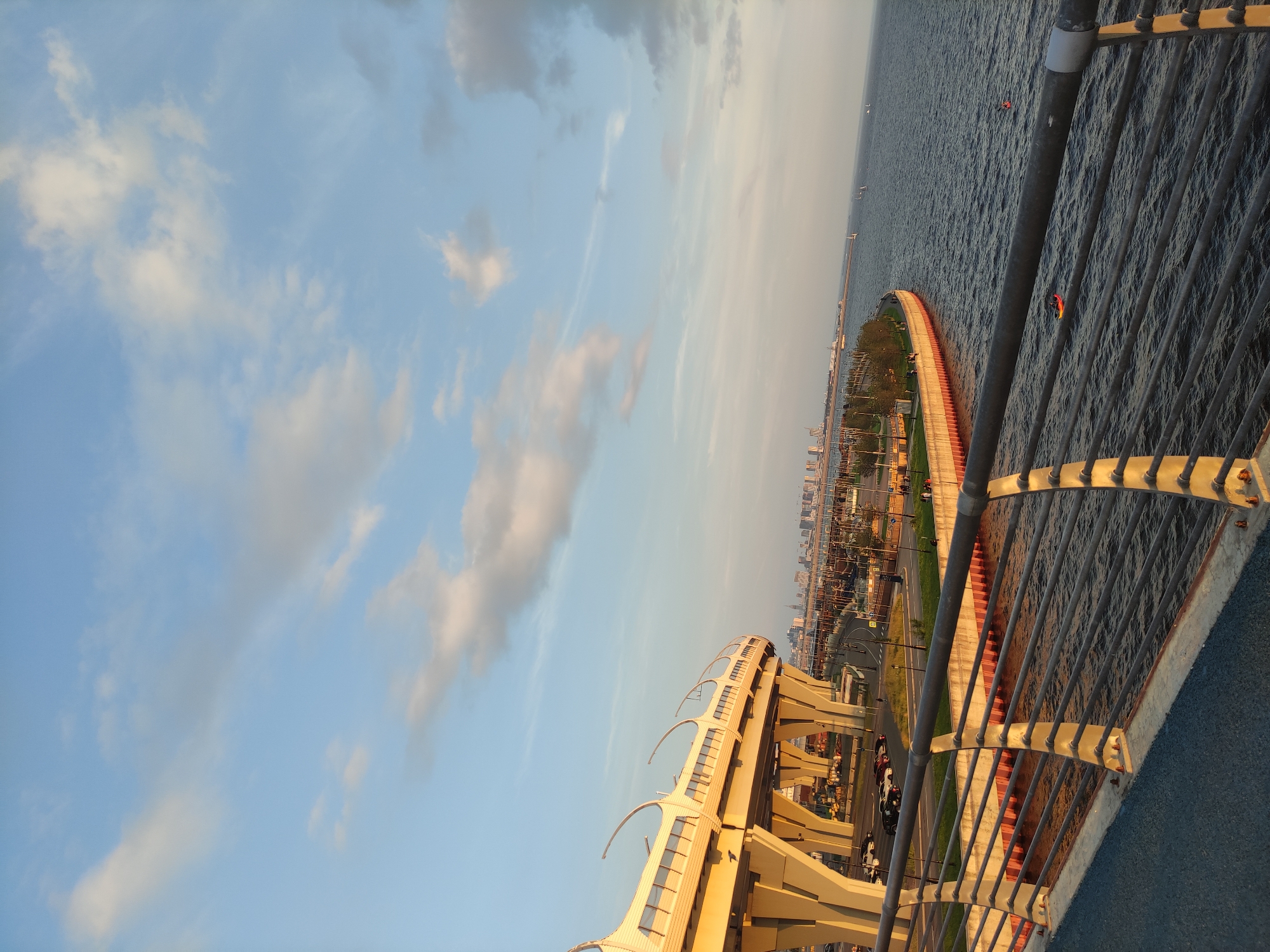 City skyline and waterfront at golden hour, boats passing through