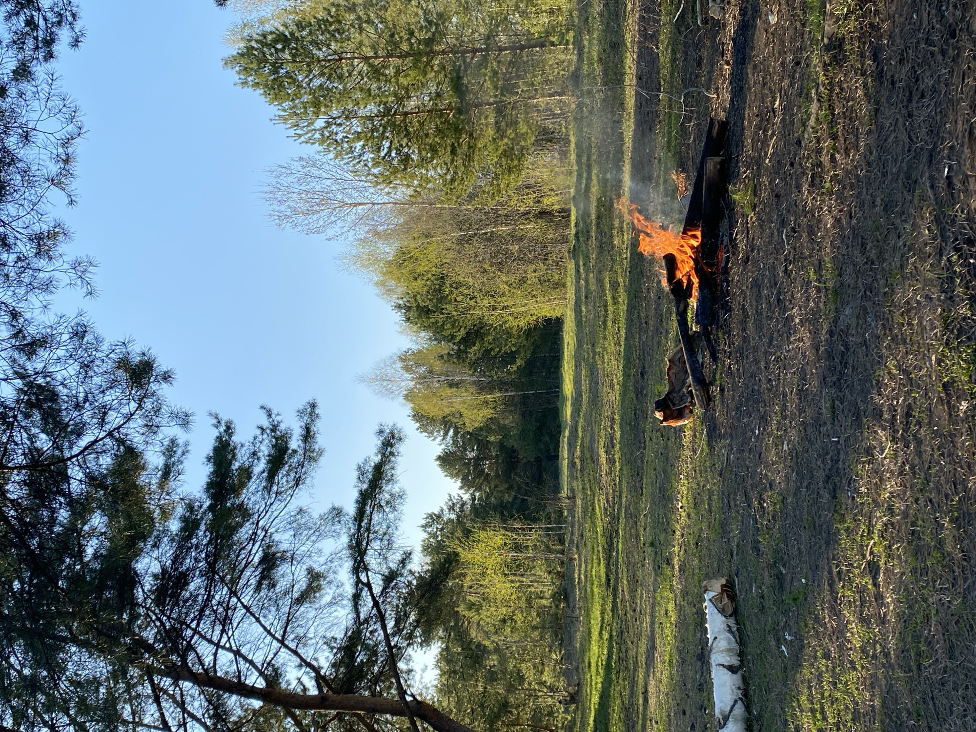 Spring day captured near Chaikovsky: controlled burn, river reflections