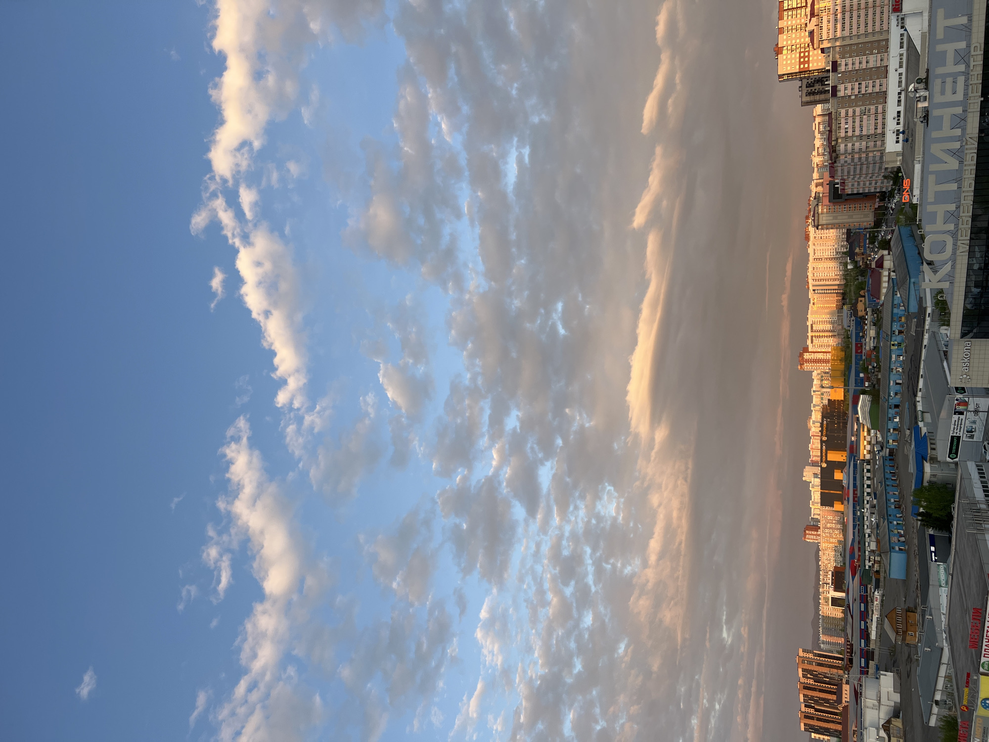 Partly cloudy evening sky observed over Krasnoyarsk cityscape