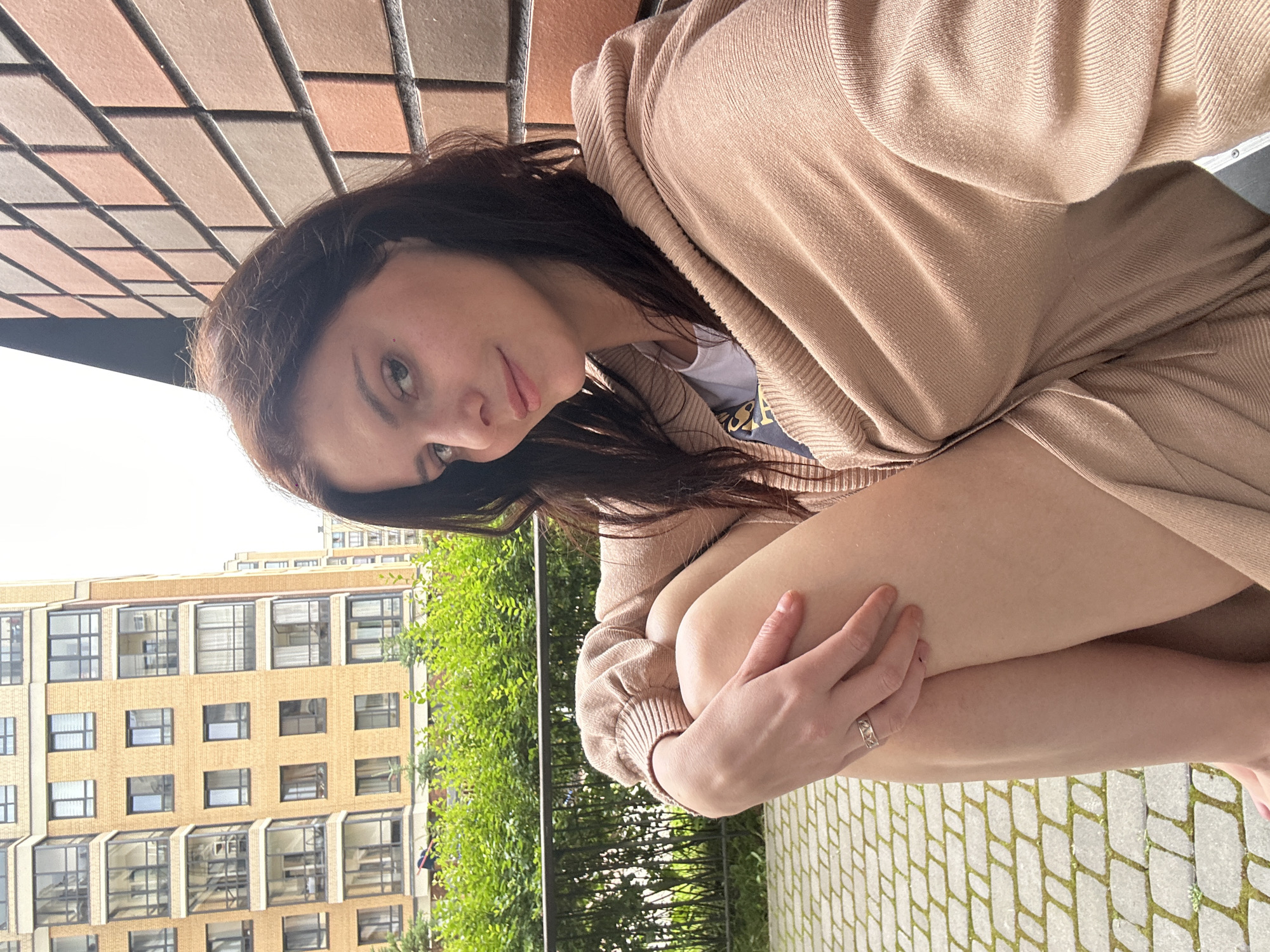 Relaxed moment outside a brick apartment building, cloudy morning