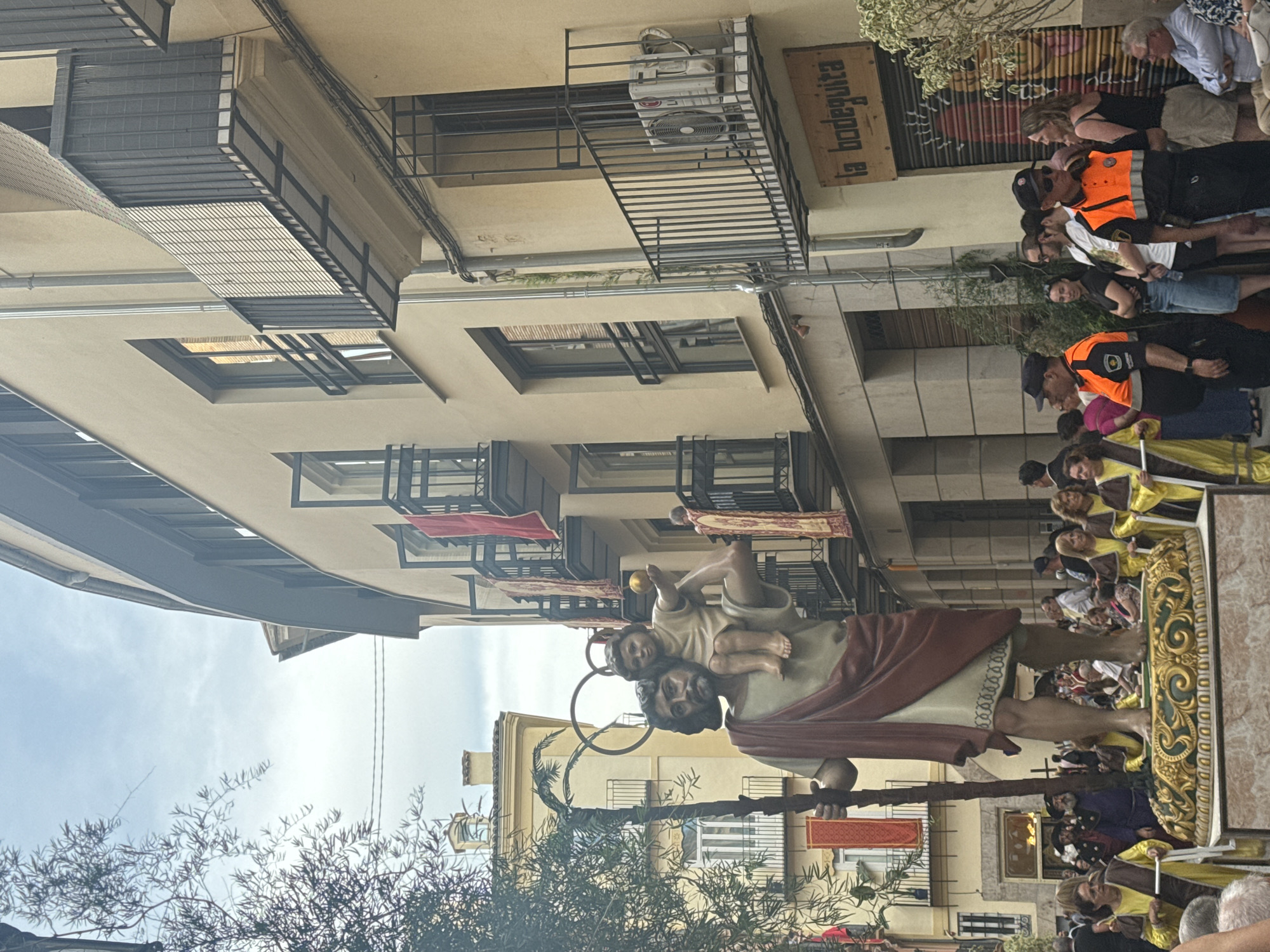 Religious procession with saints' statues winds through València Old Town