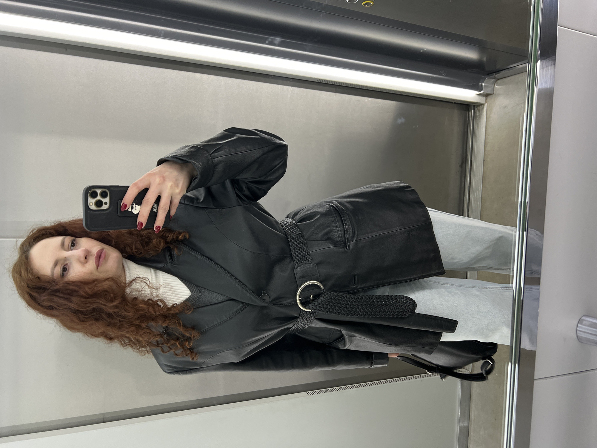Woman takes mirror selfie in Saint Petersburg elevator