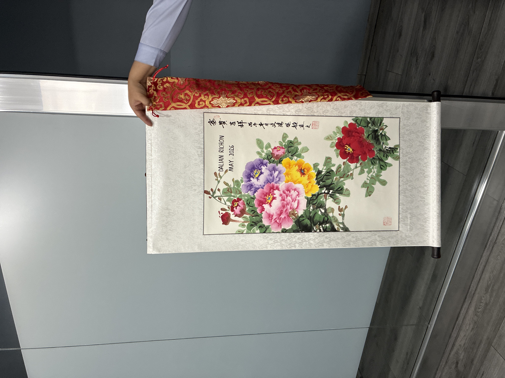 Person examines Chinese peony scroll painting in Cuautitlán Izcalli