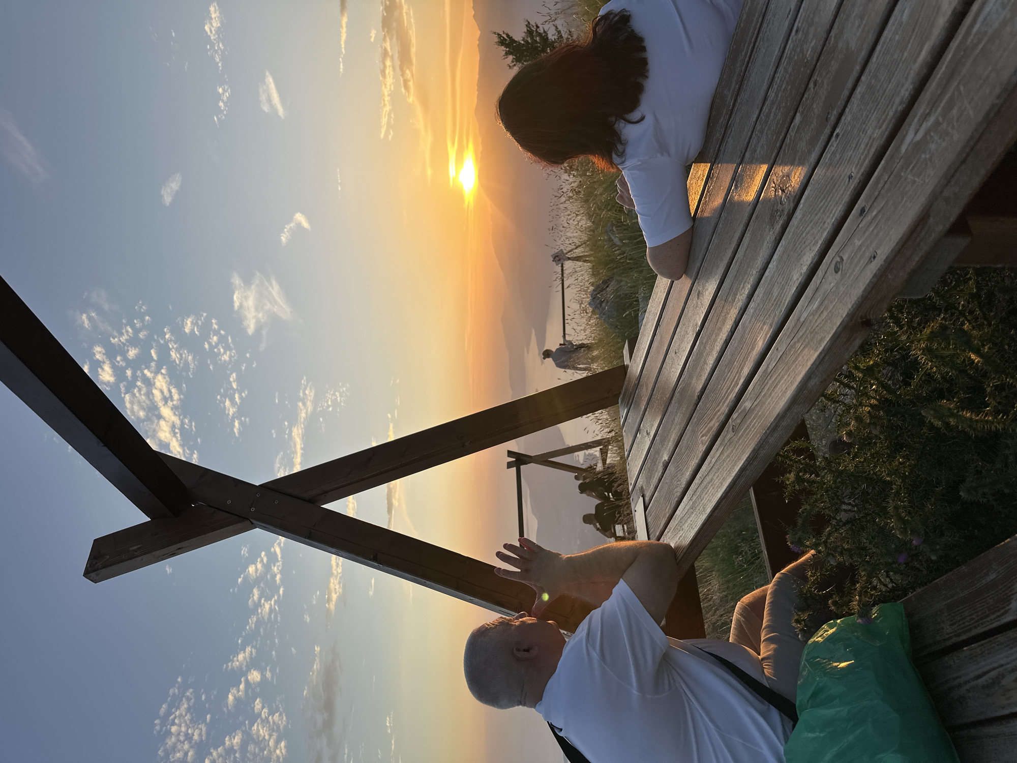Couple watches sunset over bay from picnic table in Montenegro