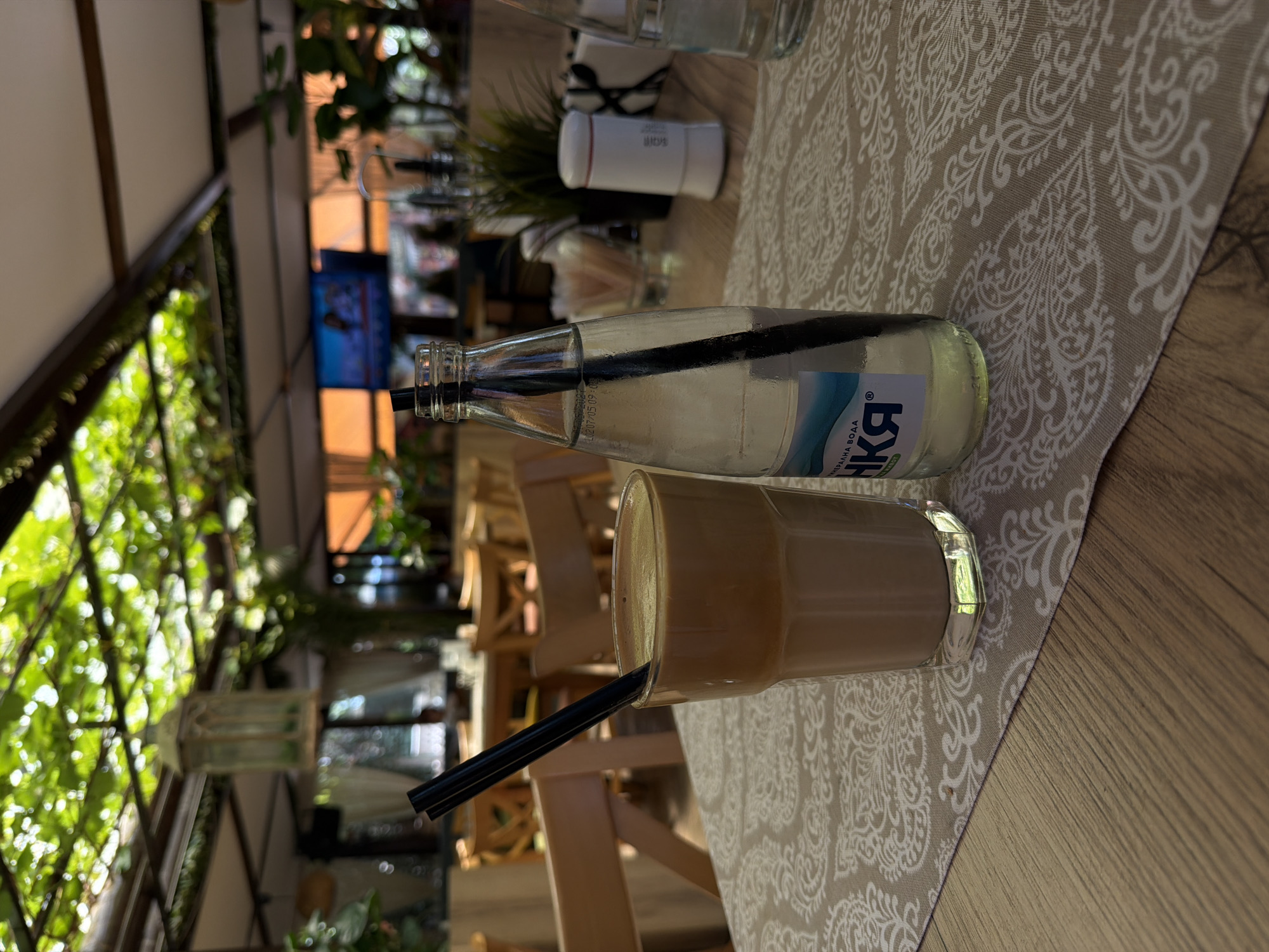 Frappe and mineral water at a shaded outdoor café in Blagoevgrad
