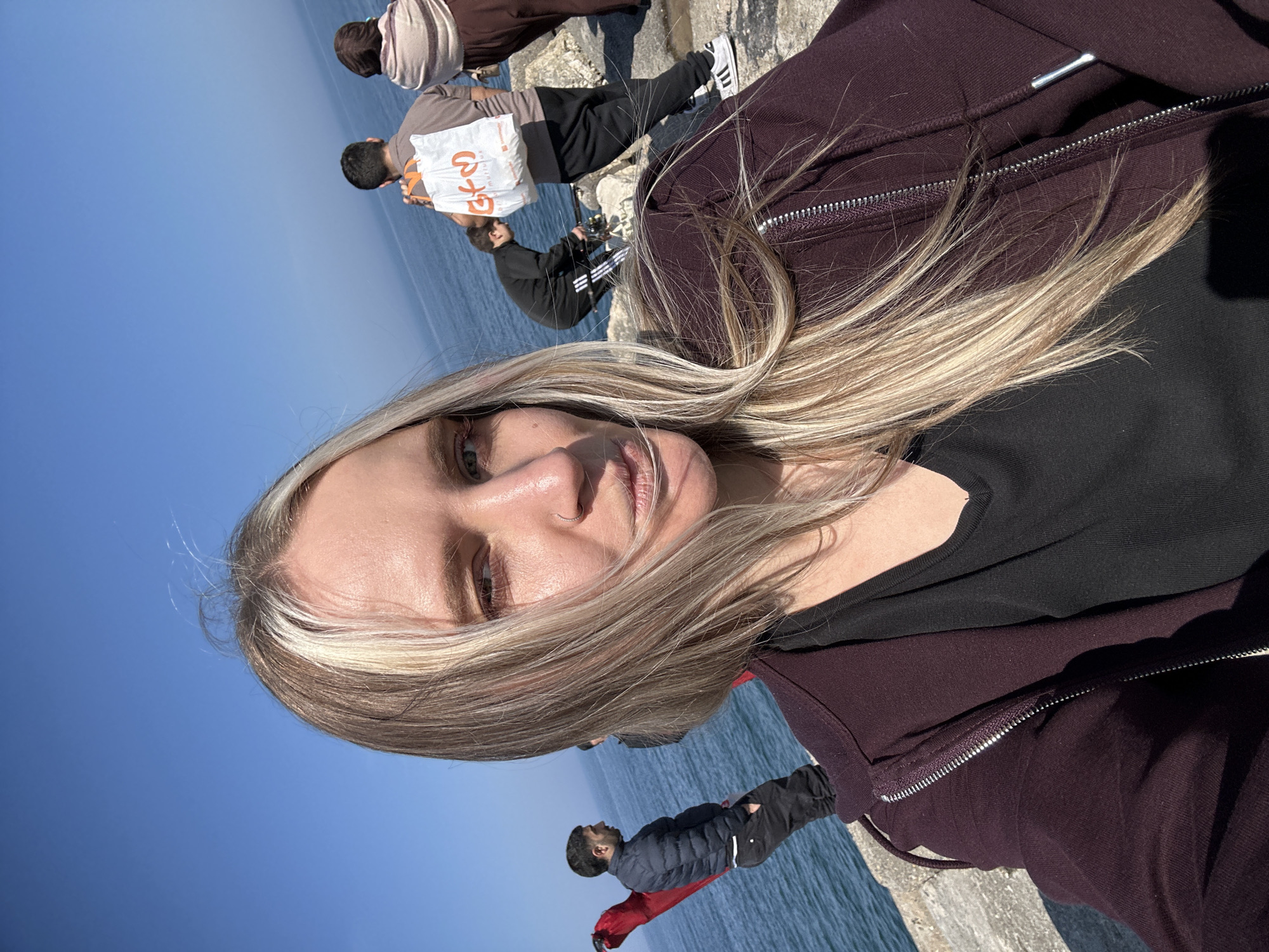 Girl stands on seaside concrete structure in Arnavutköy