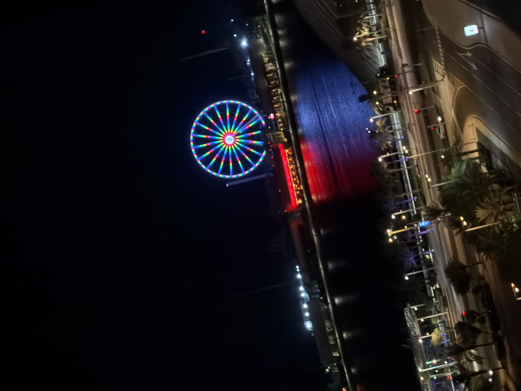 Late-night Ferris wheel and drinks at a city waterfront