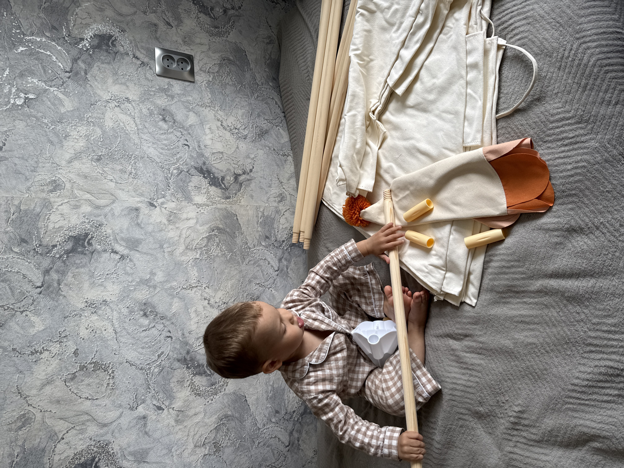 Child plays with tent in pajamas during morning hours