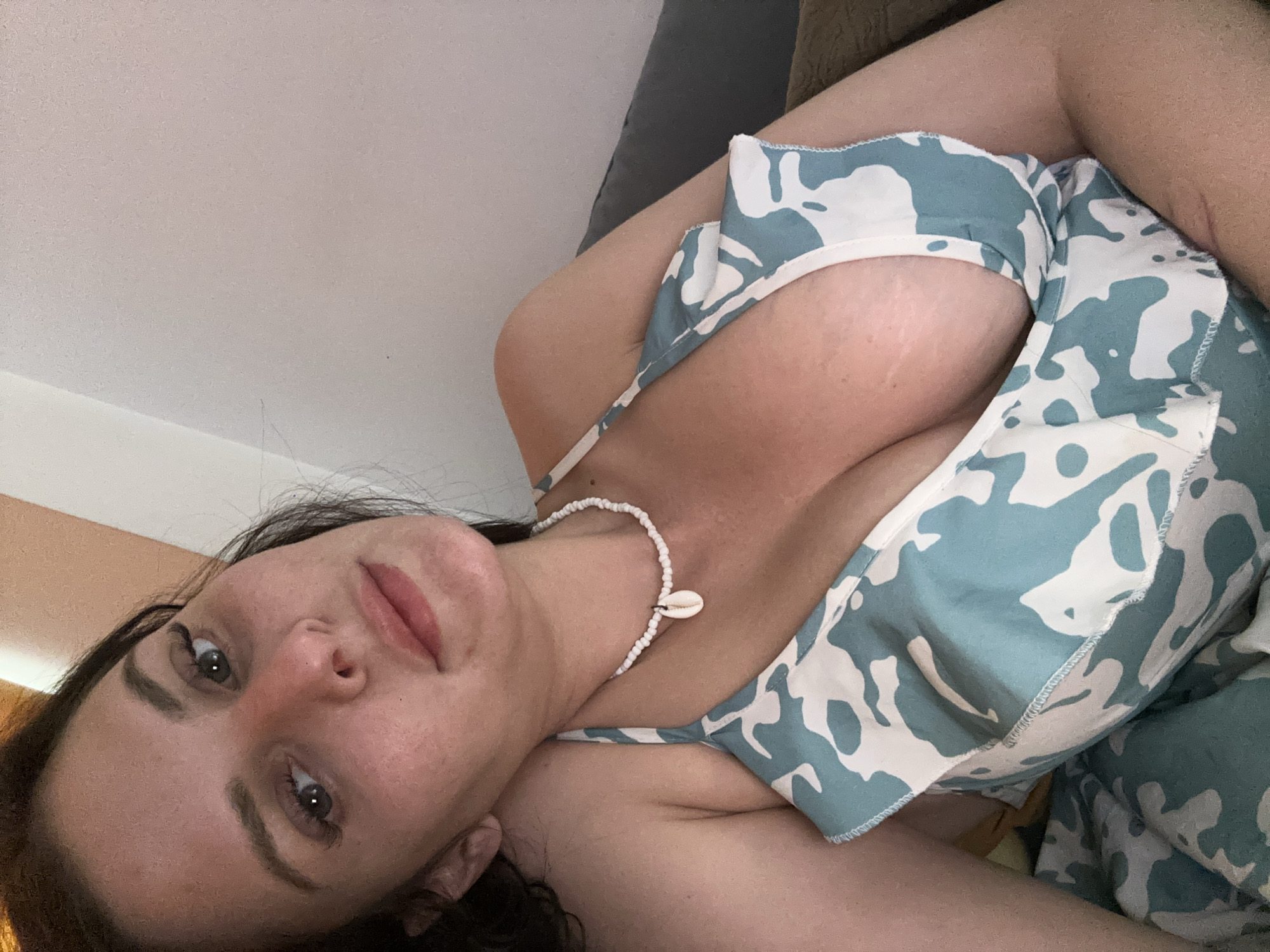Casual selfie session on a couch, blue patterned outfit and shell necklace