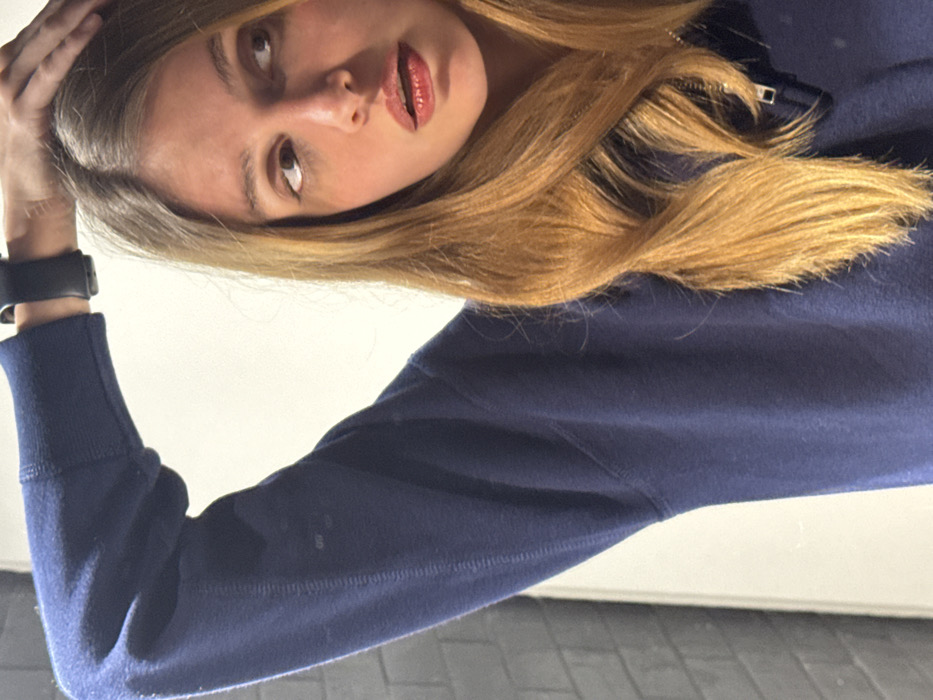 Woman takes mirror selfies in navy sweatshirt, Tbilisi