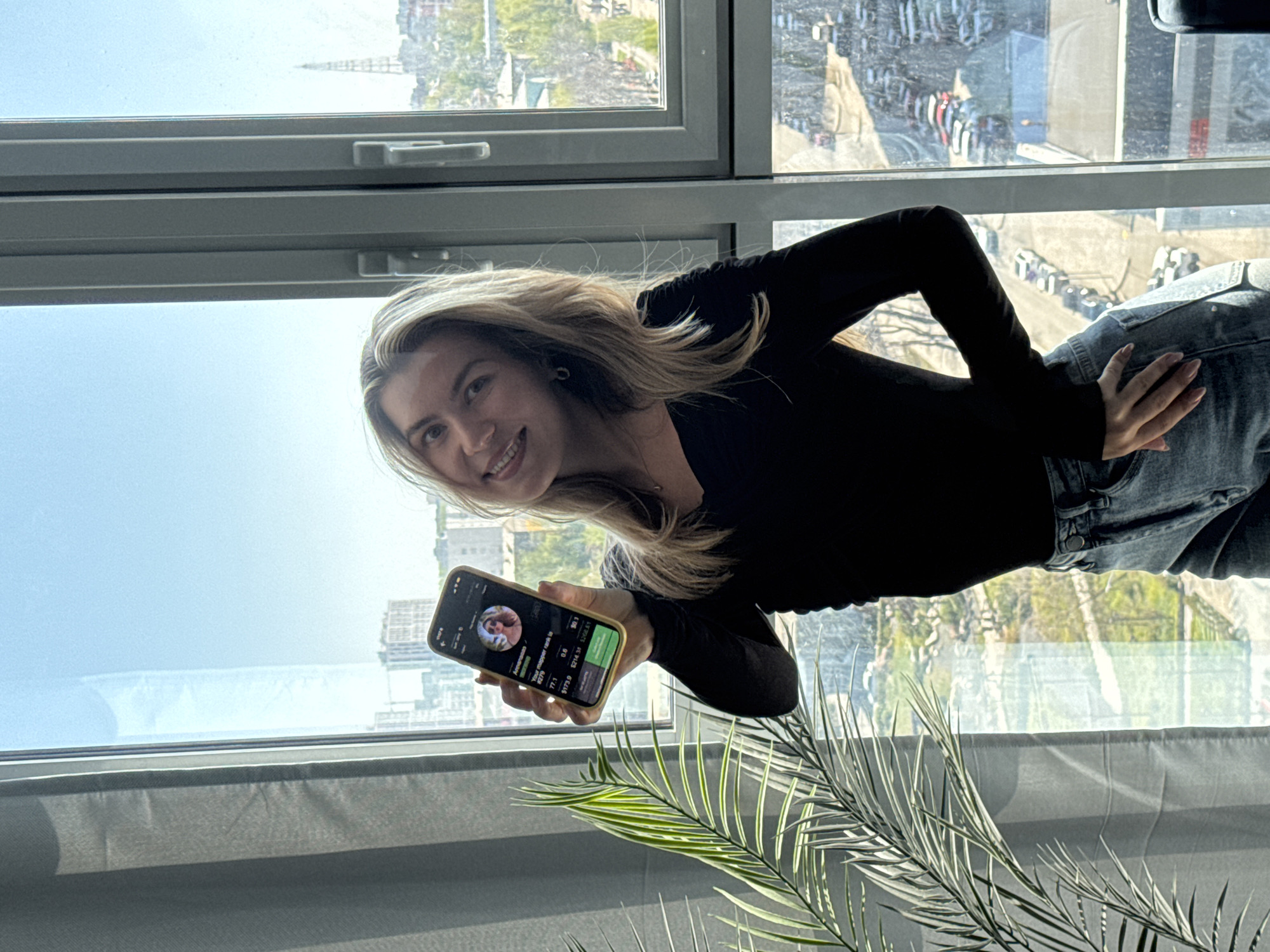 Woman checks financial data by window during morning hours