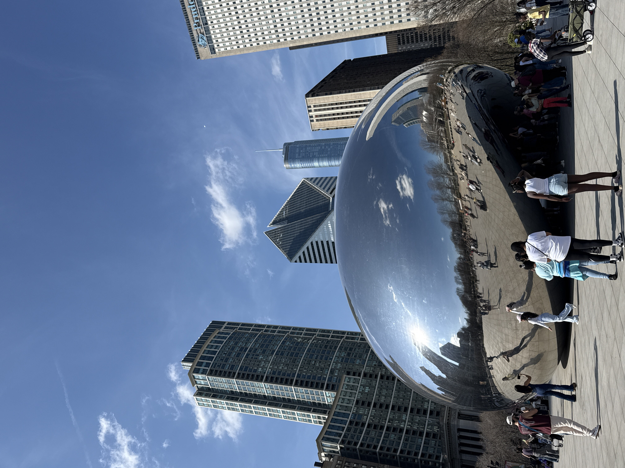 Tourist photographs Cloud Gate sculpture in Chicago's Millennium Park