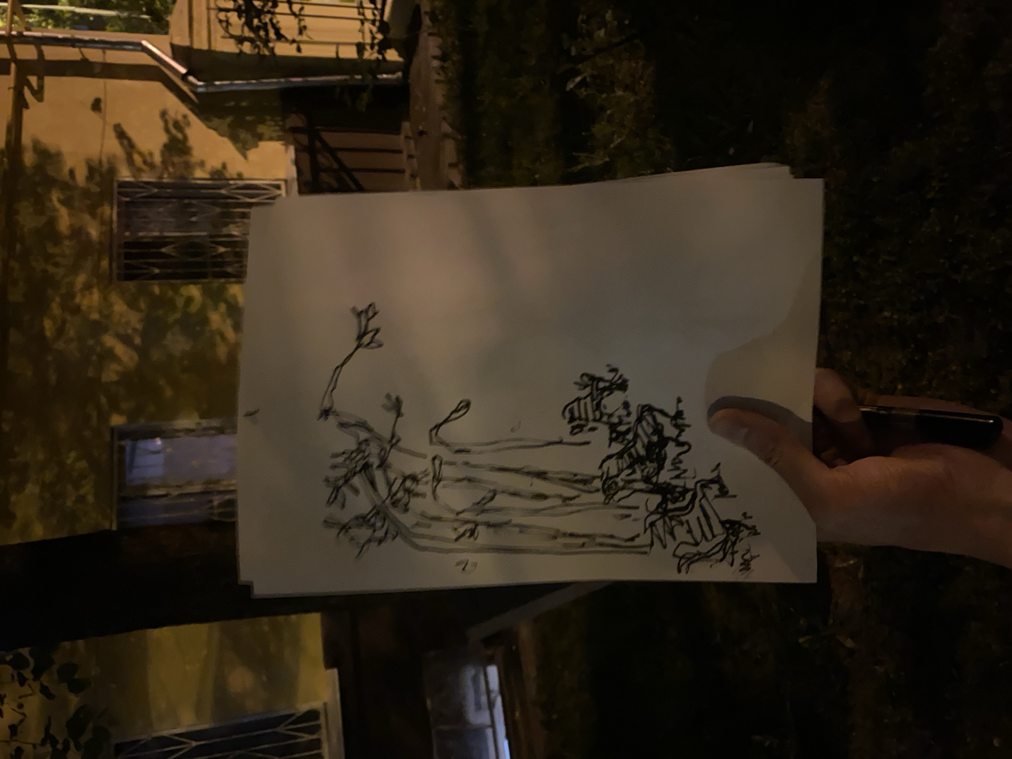 Person displays hand-drawn sketches including portrait outside Moscow building