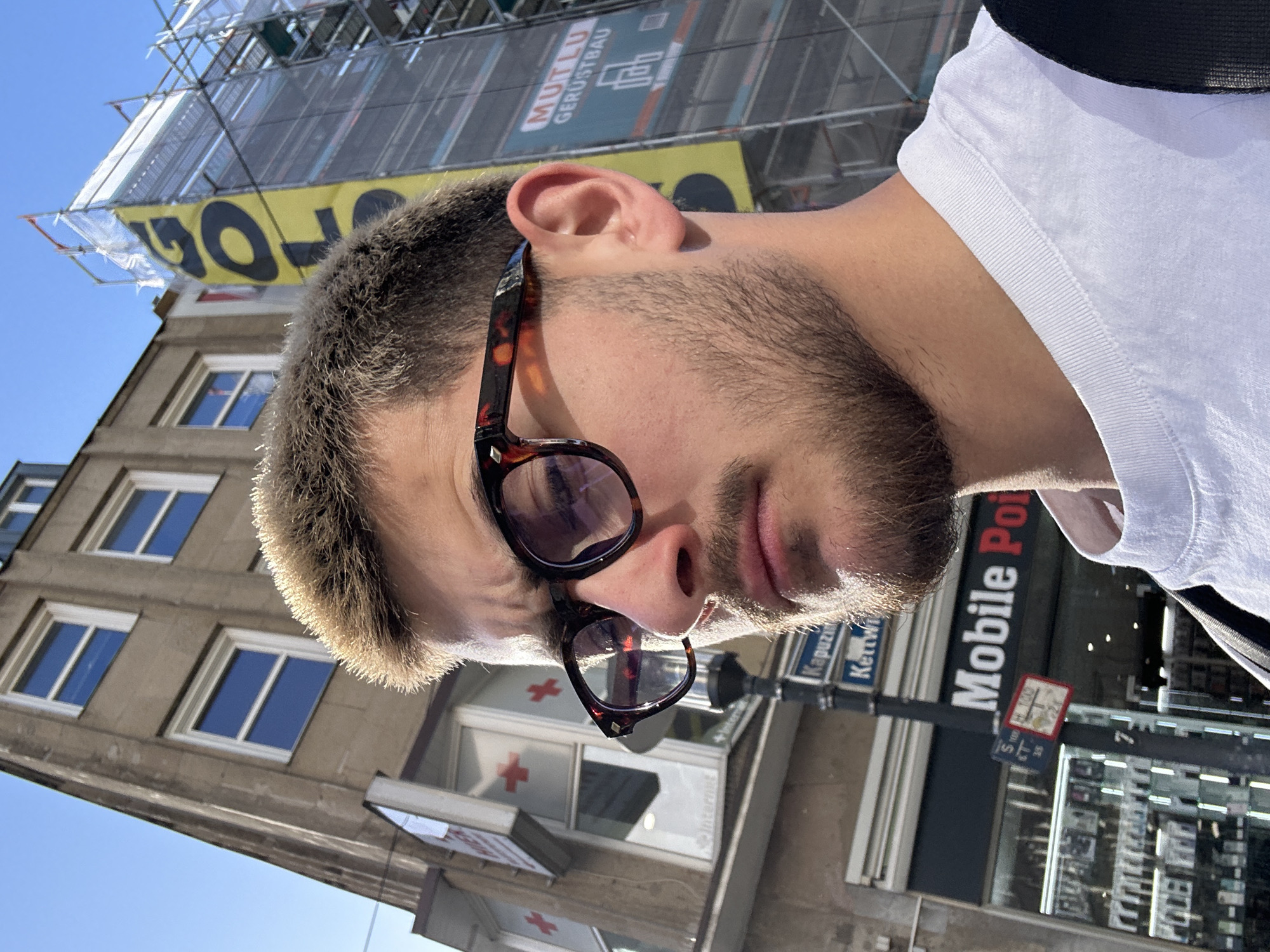Man takes selfies on Essen street in afternoon sunlight