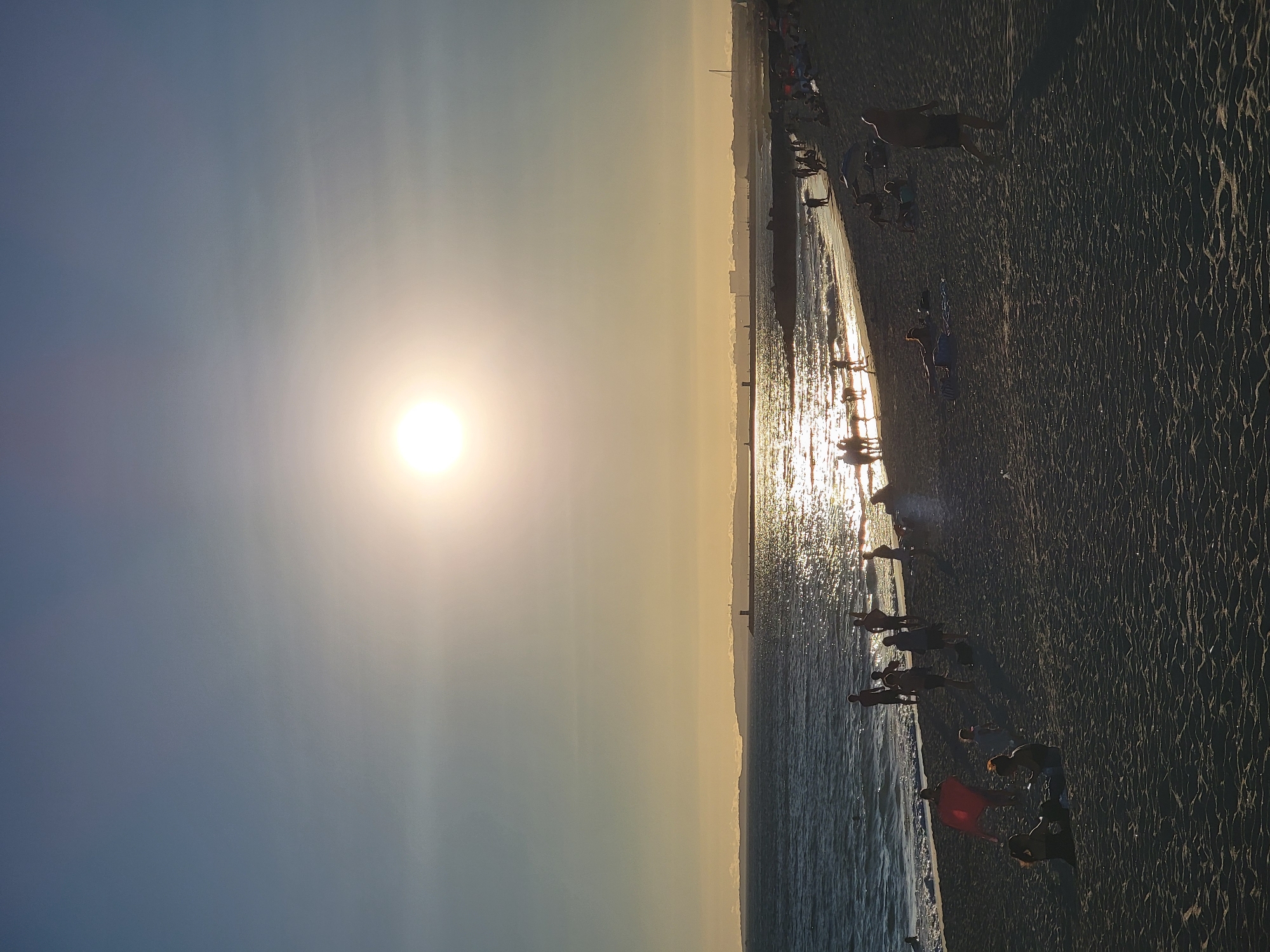 Late afternoon at Quarteira beach, phones out by the water