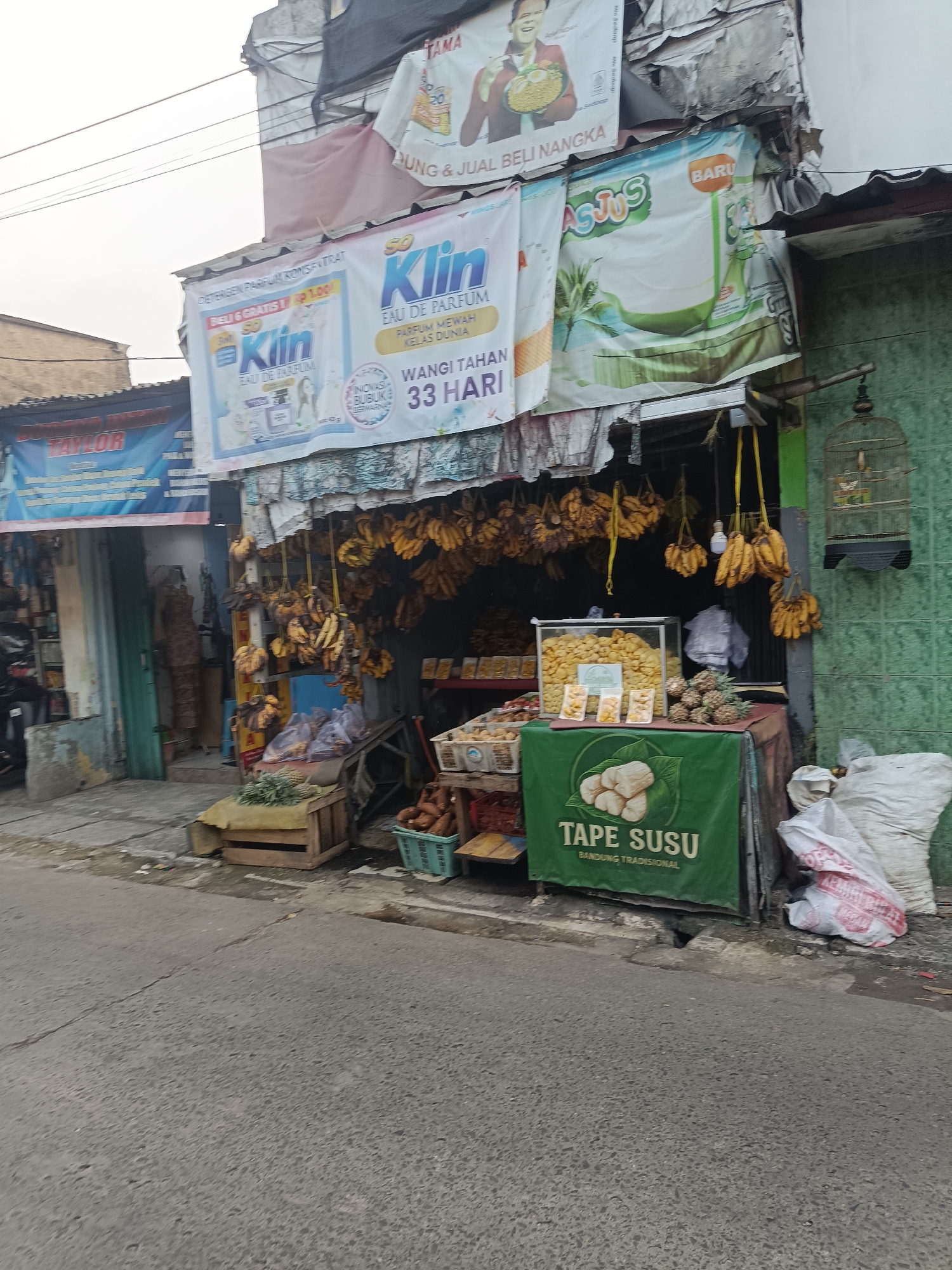 Street-level commerce and daily life along a Depok neighborhood strip