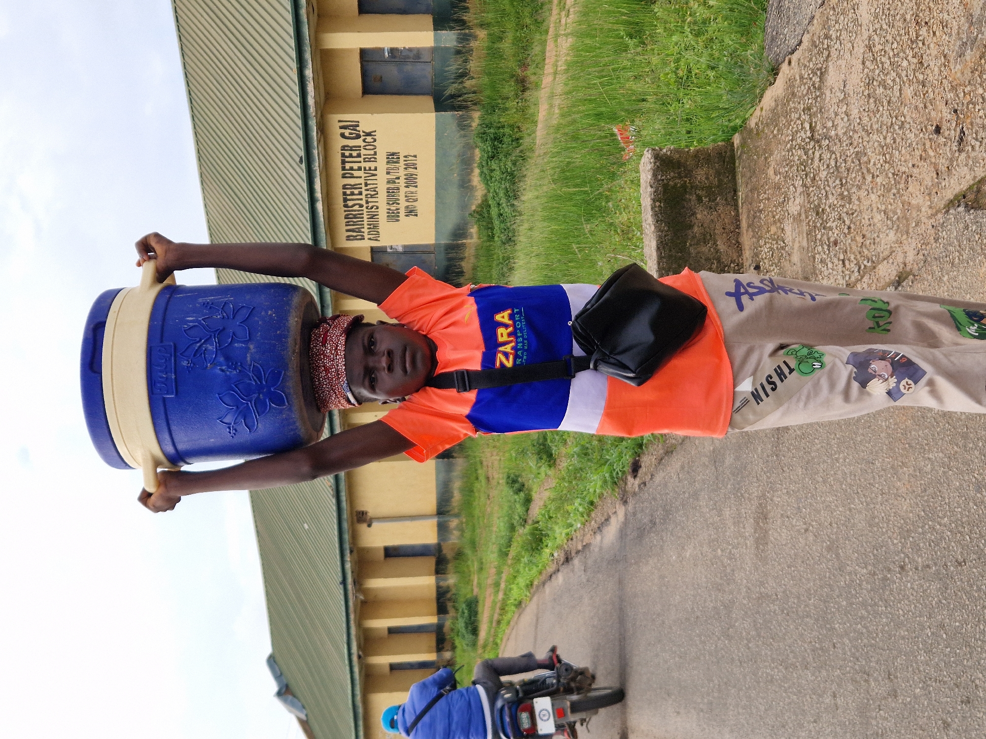 Morning foot traffic in Kabong, Nigeria, people carrying everyday loads