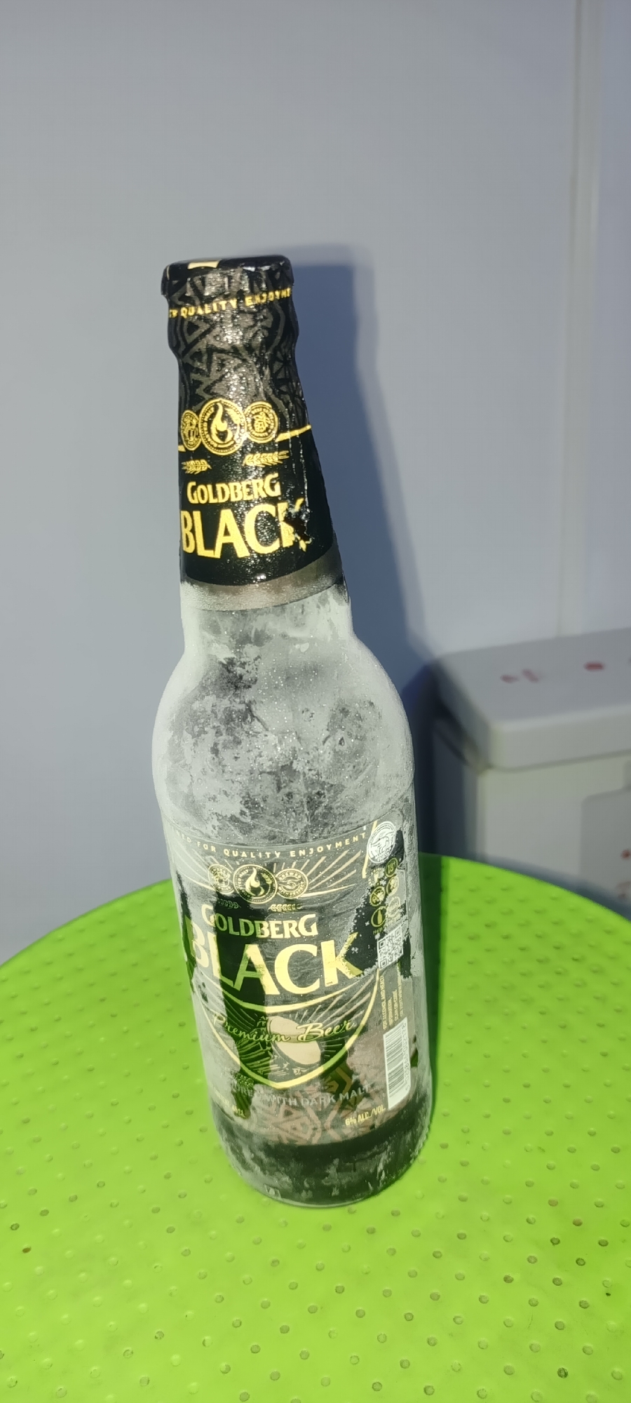Iced Goldberg Black Premium Beer bottle on green surface