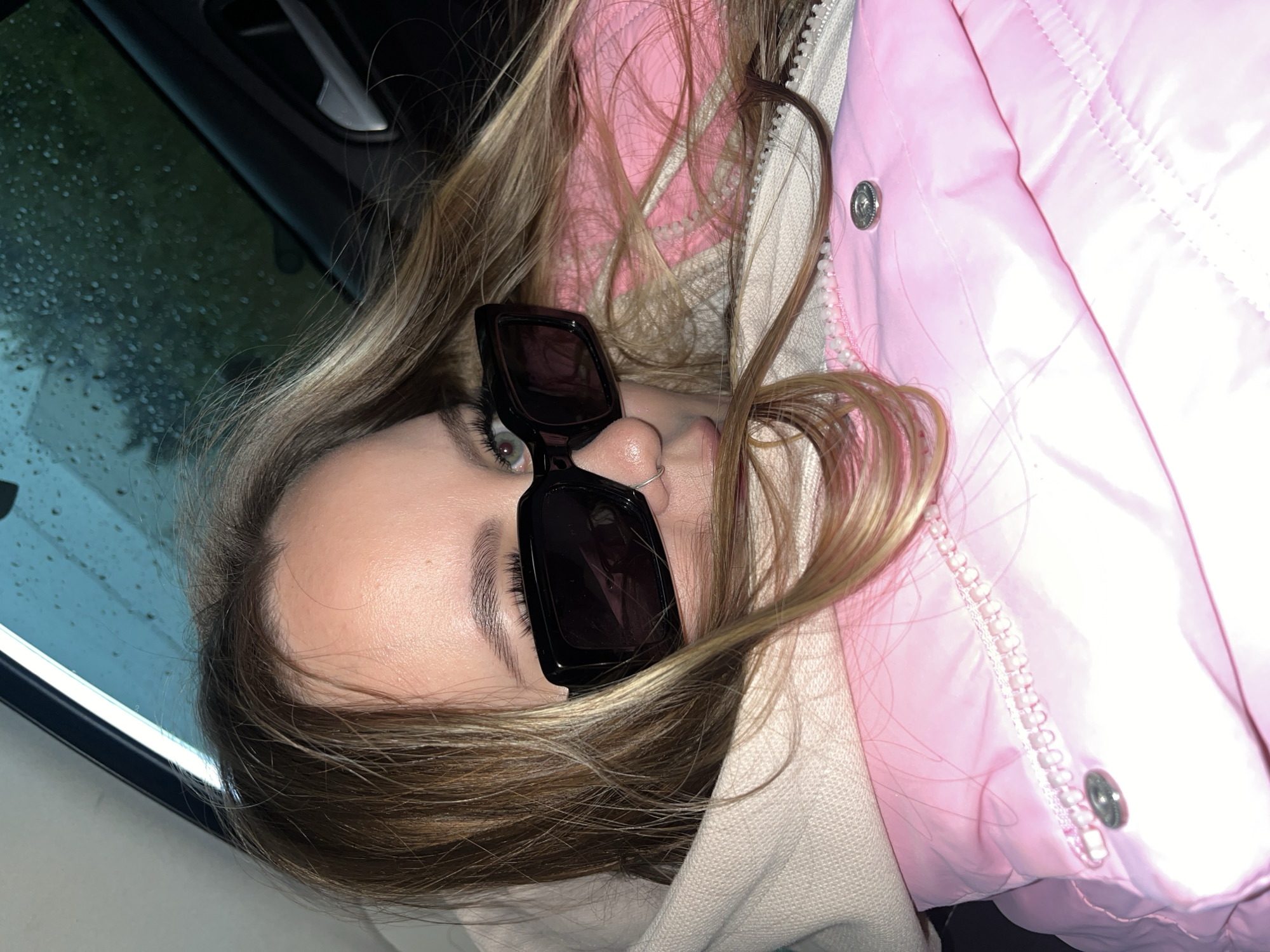 Woman takes selfies in vehicle during overcast afternoon