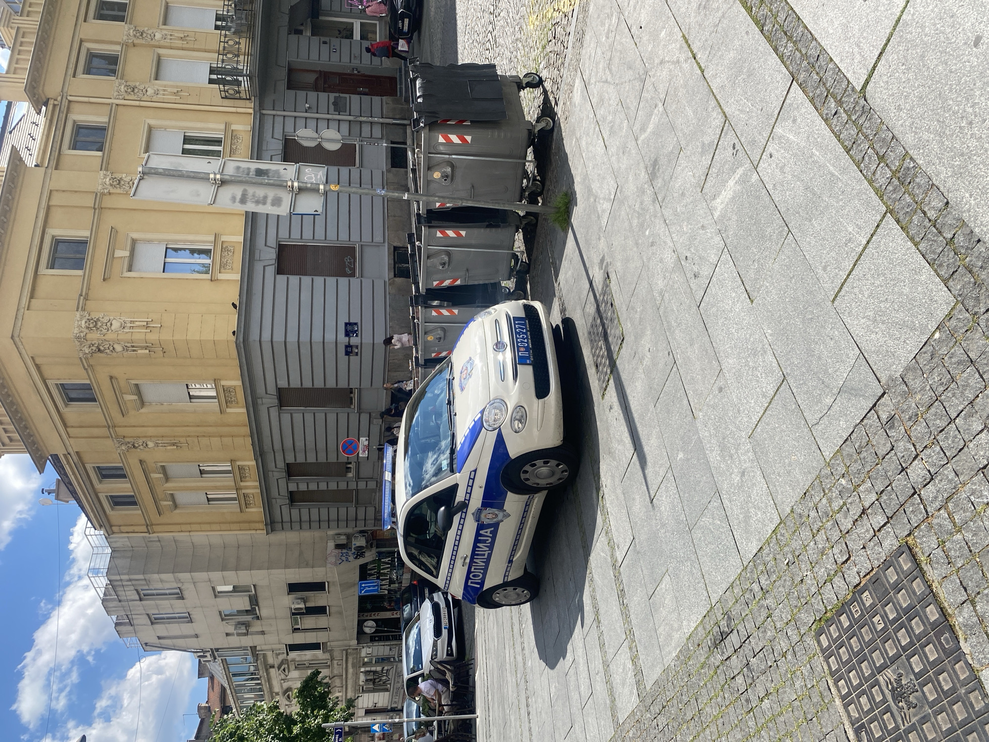 Police car parked near waste containers on Belgrade street