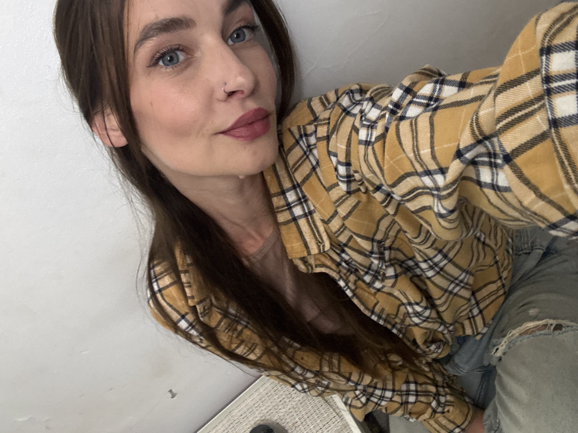 Woman takes selfie in mustard plaid shirt in Bat Yam