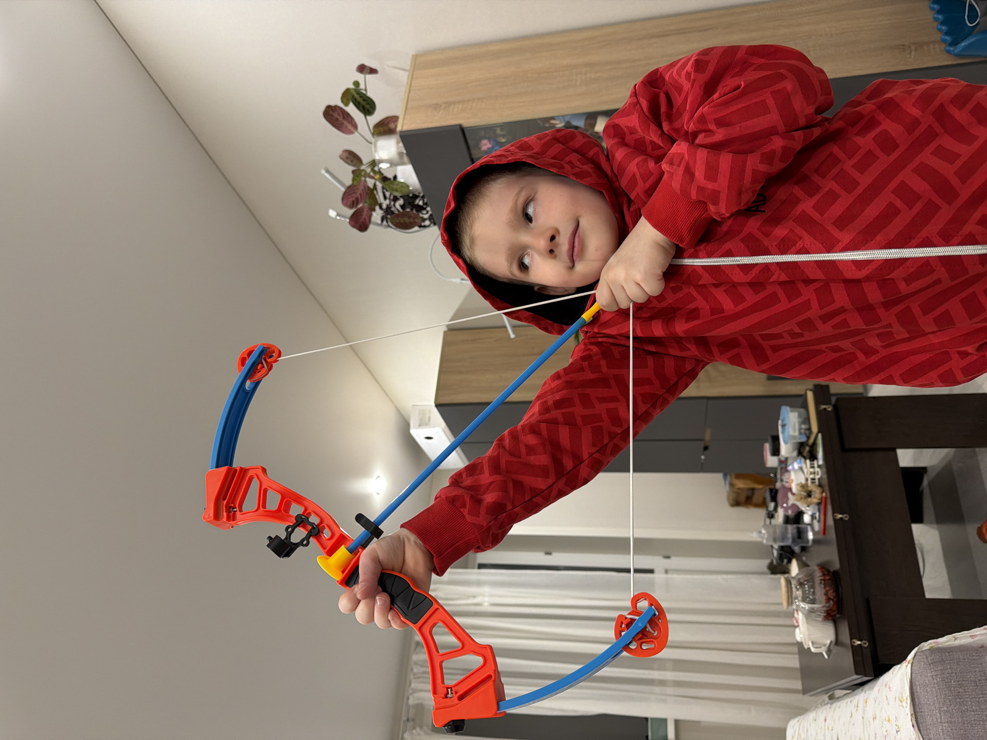 Child plays with toy bow in Russian home