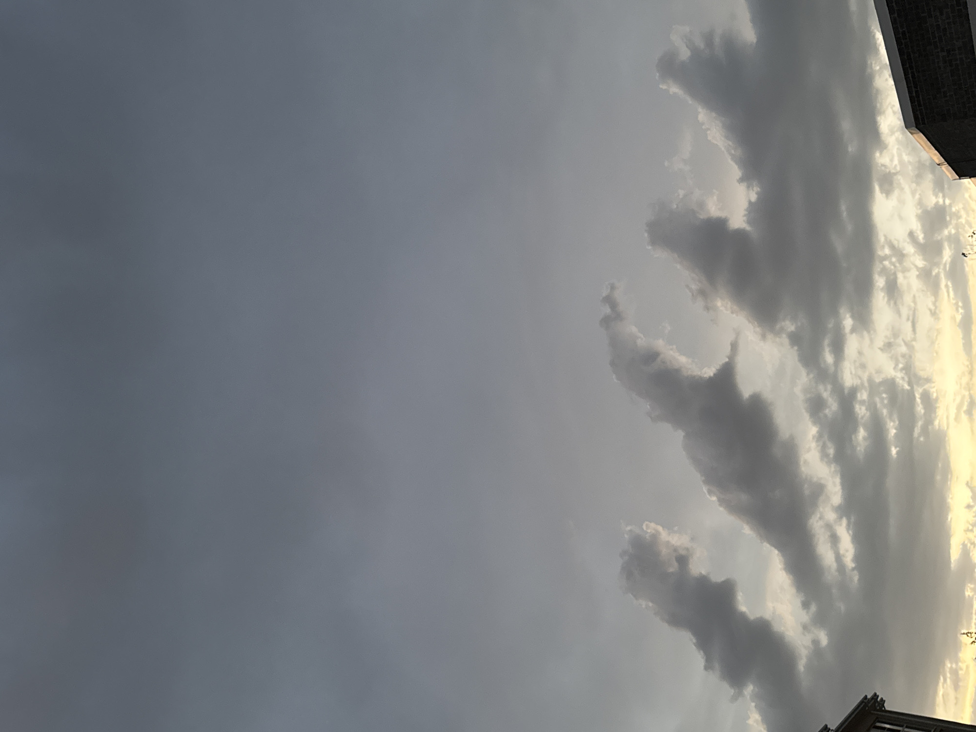 Storm clouds roll in at dusk over an urban construction site.