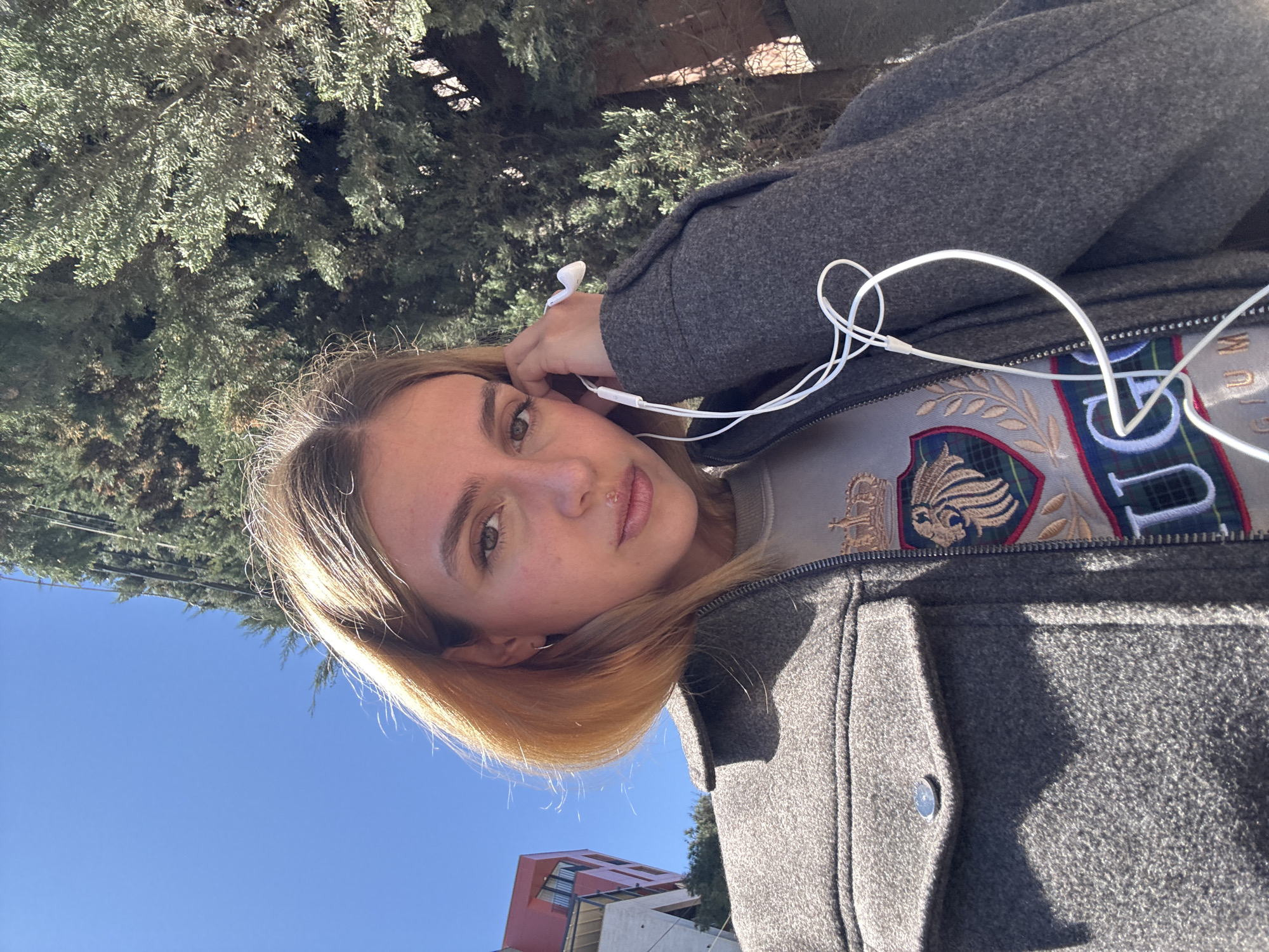Woman takes selfie near construction site on sunny morning