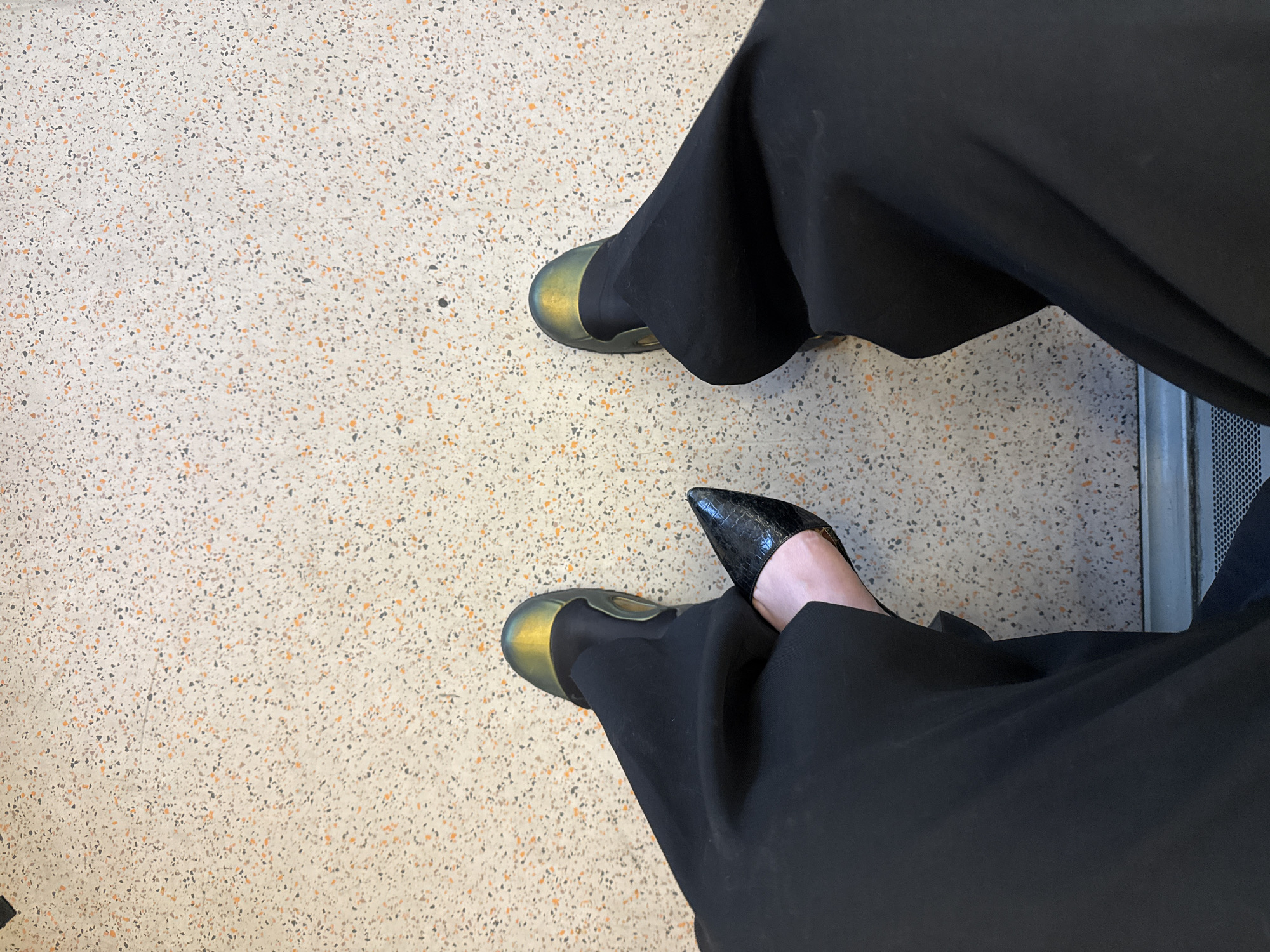 Person in black trousers seated in London public space