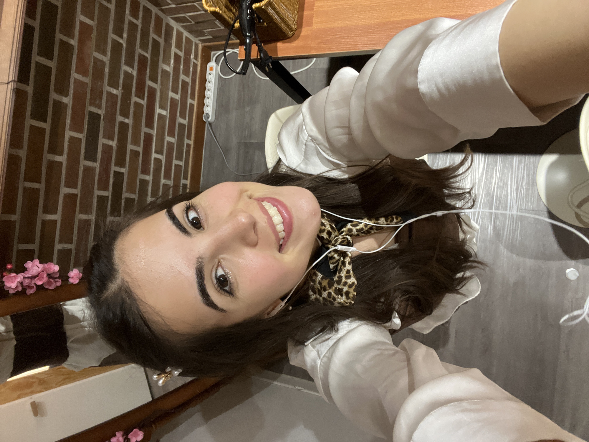 Woman takes smiling selfie in Seoul wearing leopard scarf