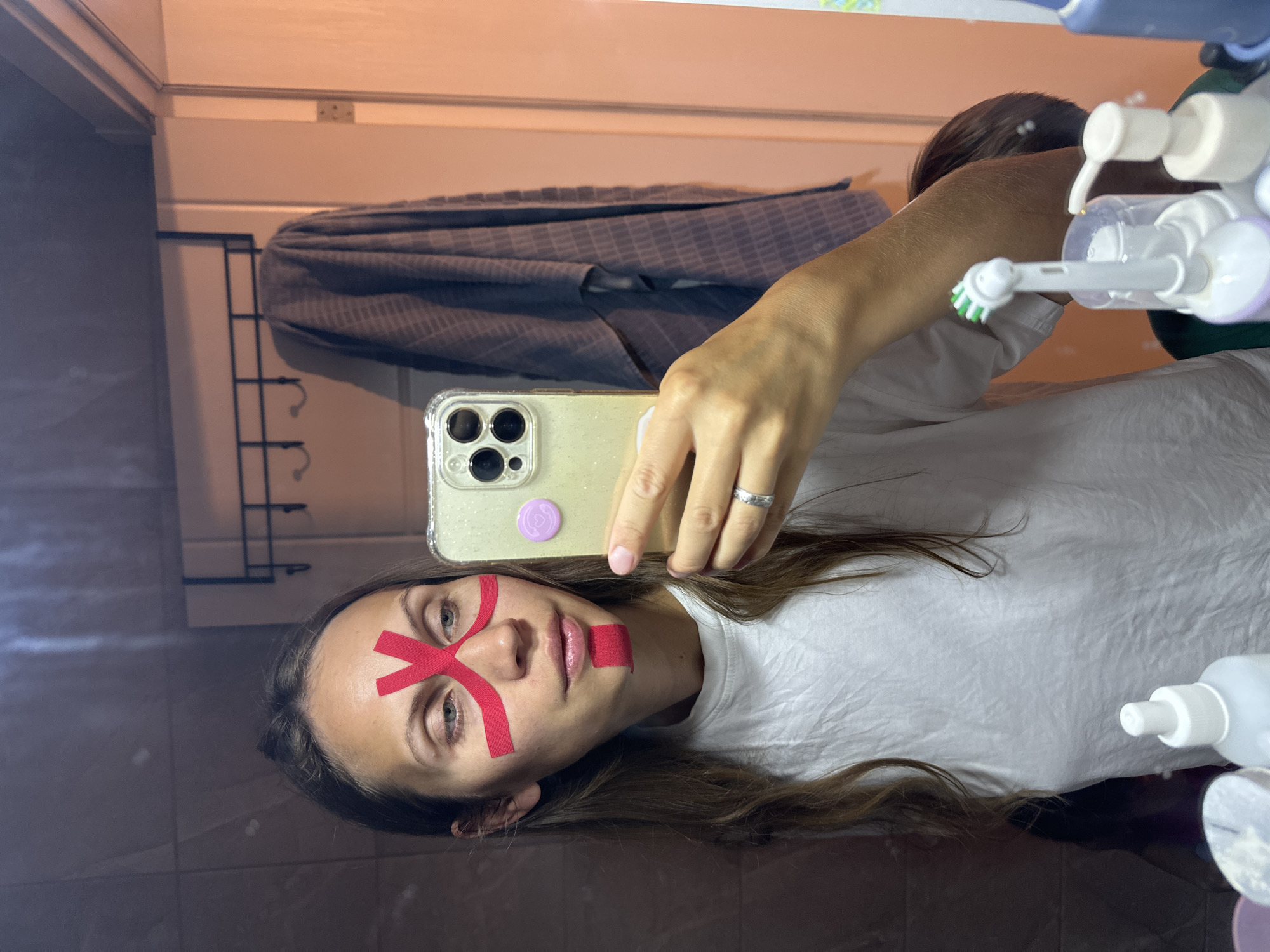 Woman applies kinesiology tape, uses light therapy device in Fethiye