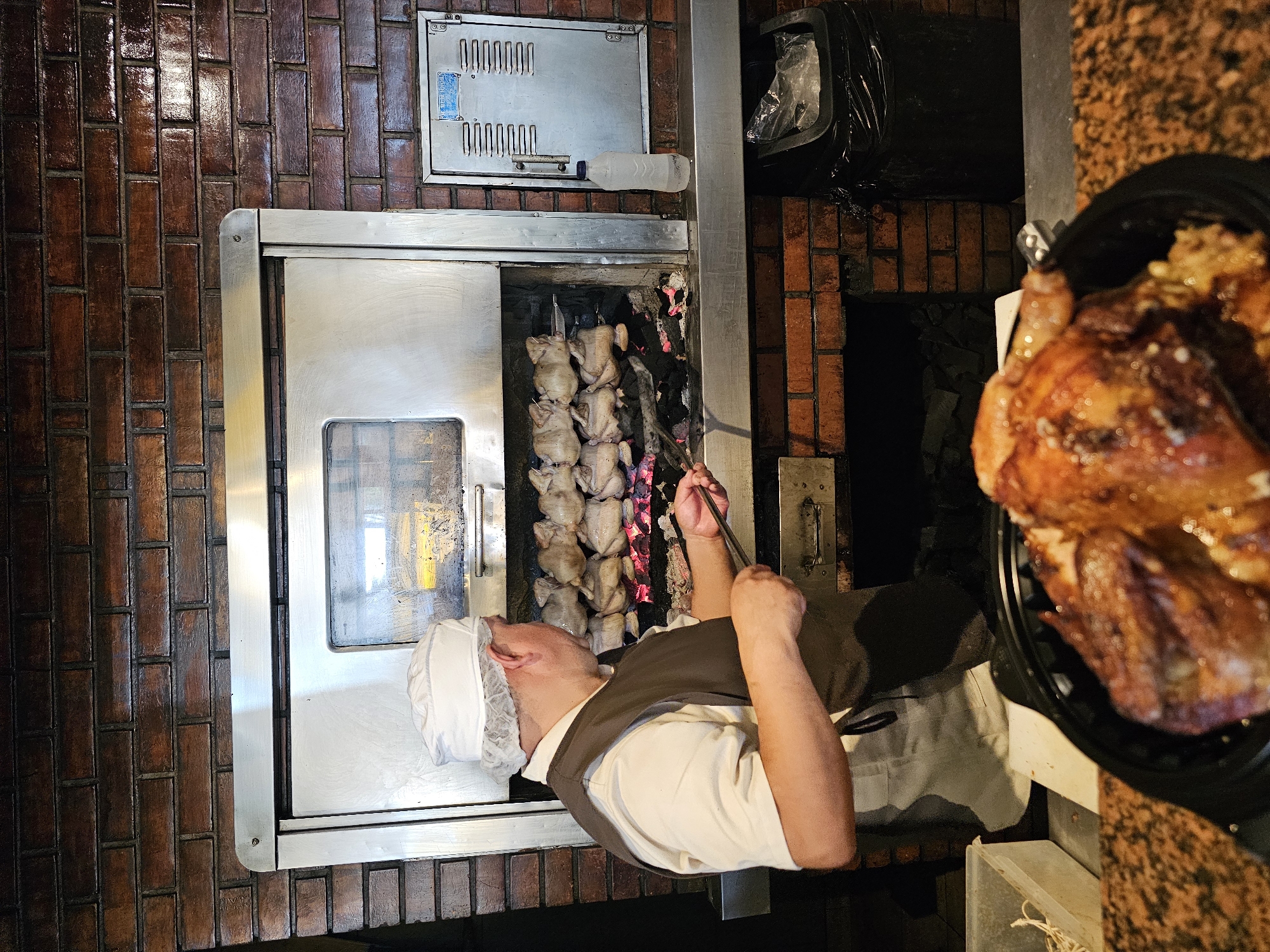 Chef prepares rotisserie chicken dinner in Miraflores restaurant