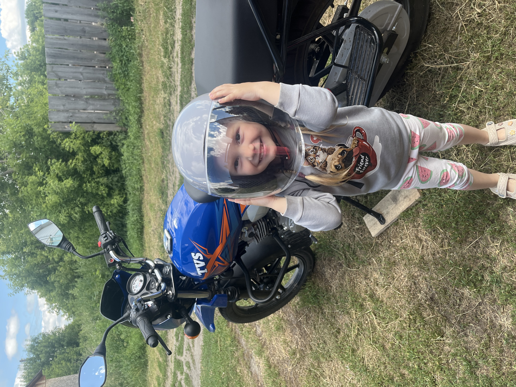 Posing on a blue motorcycle in a Russian village