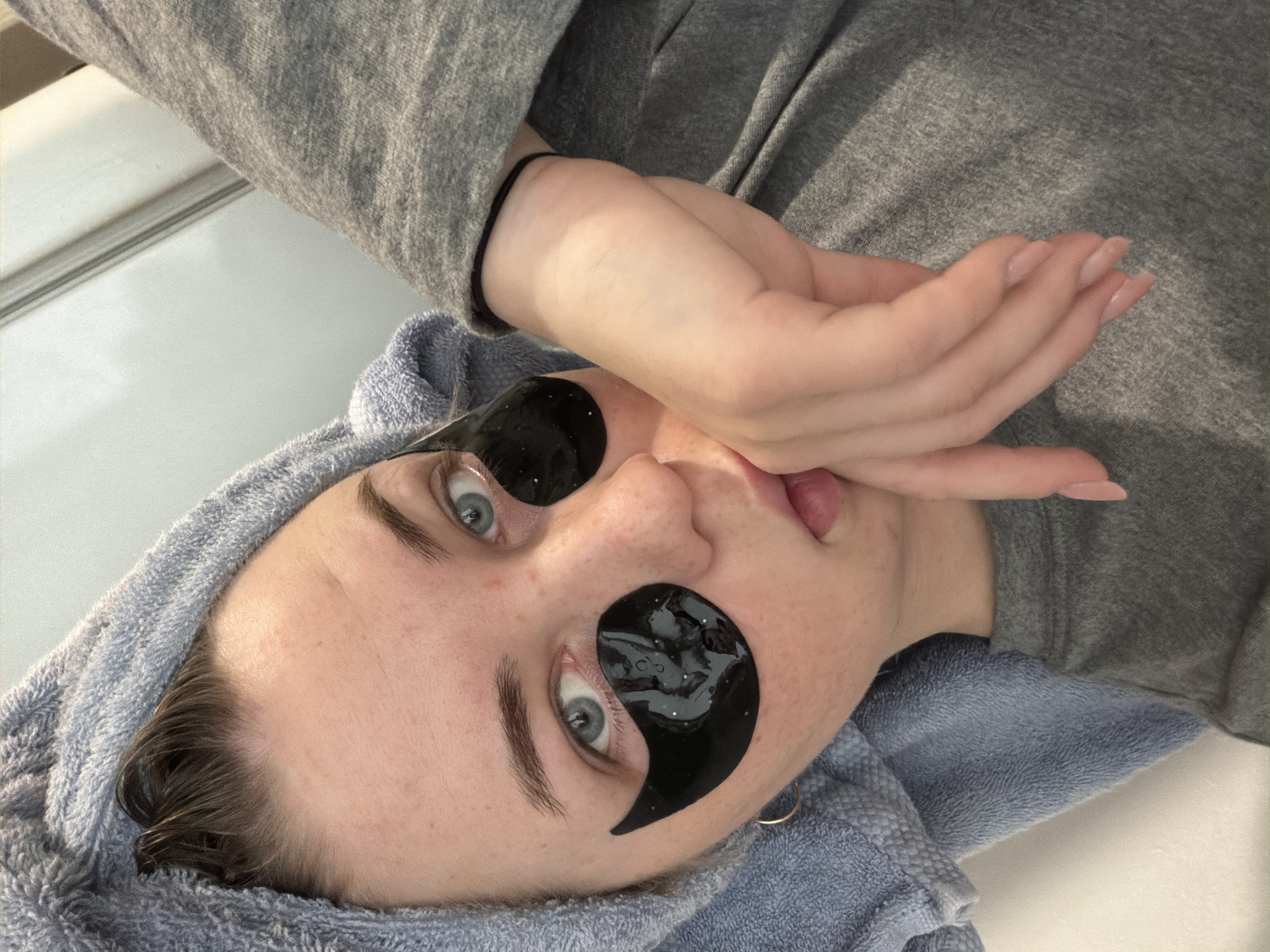 Woman conducts skincare routine with eye patches in Chaikovsky