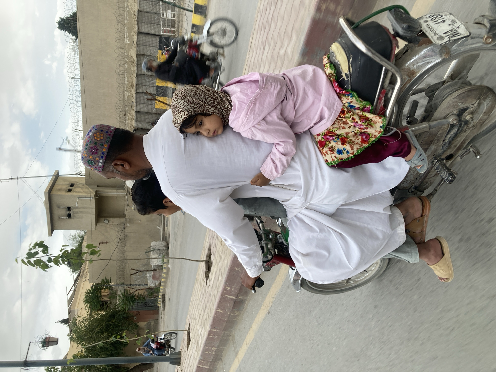 Motorcyclist in traditional dress travels through Quetta streets