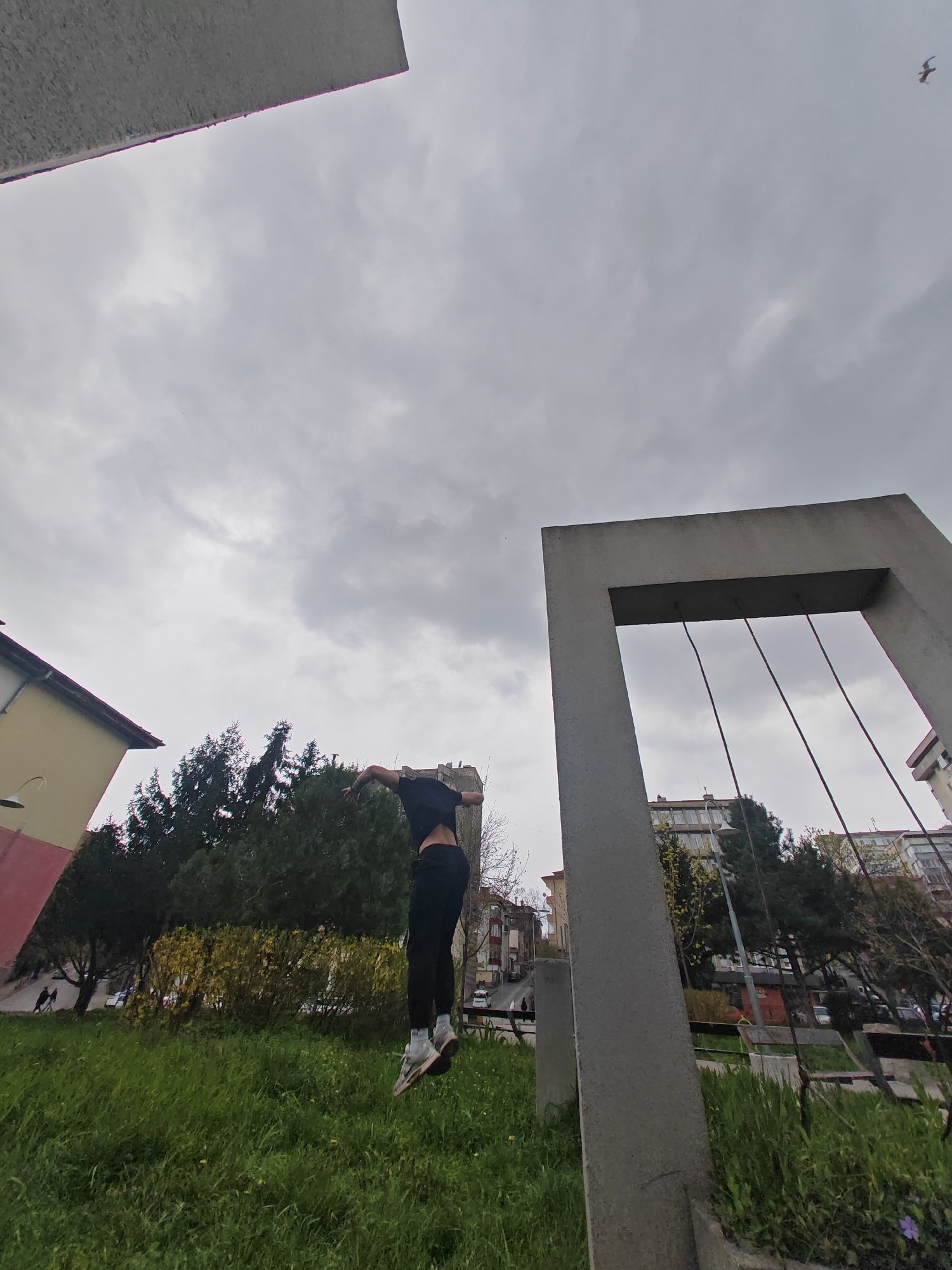 Parkour athlete performs jumps on concrete structures in urban park