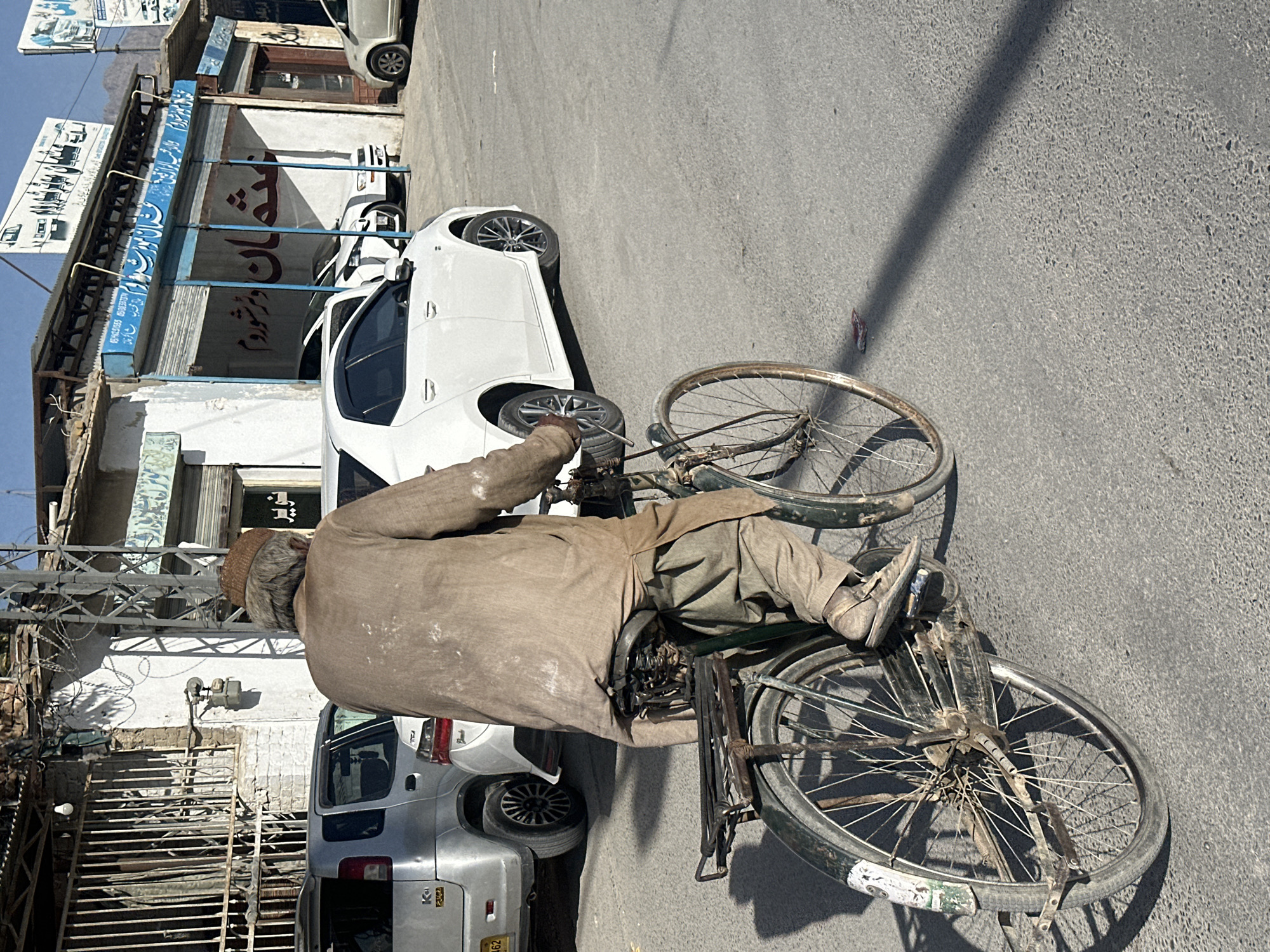 Street scenes show cyclists, motorcycles, vendors in sunny weather