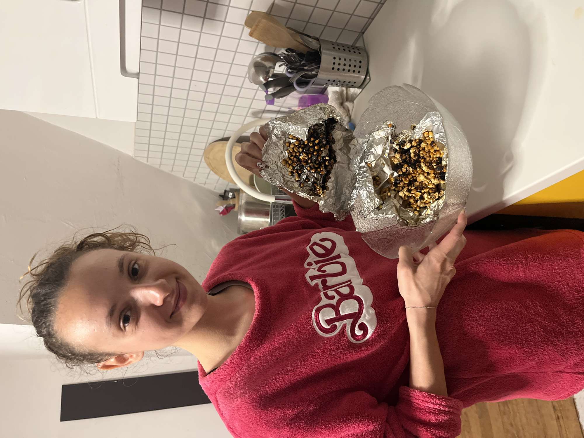 Woman displays homemade caramel popcorn in Saarbrücken kitchen