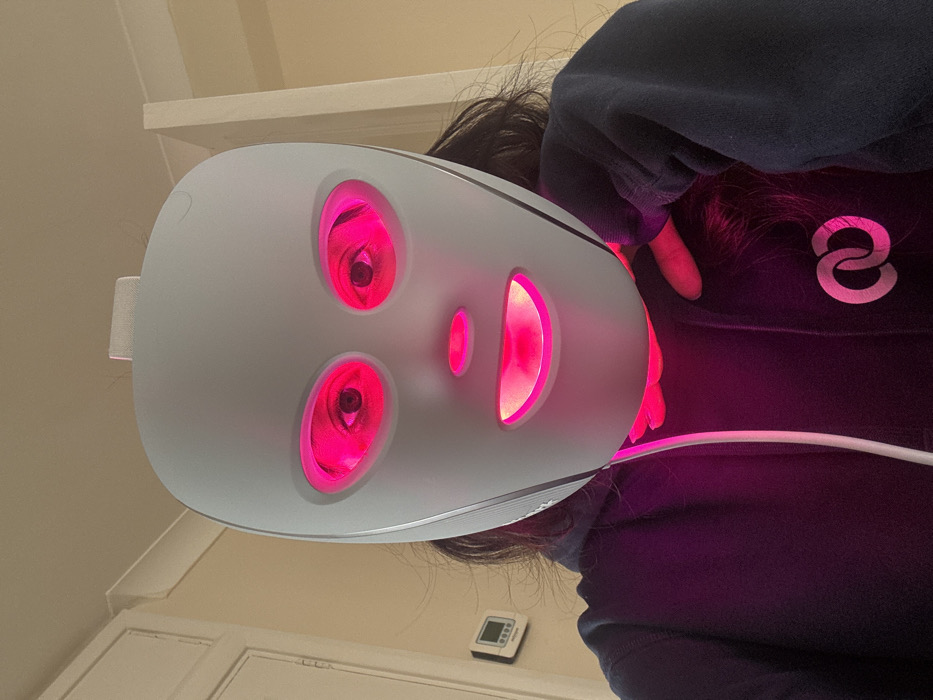 Person uses LED light therapy mask in London indoor setting