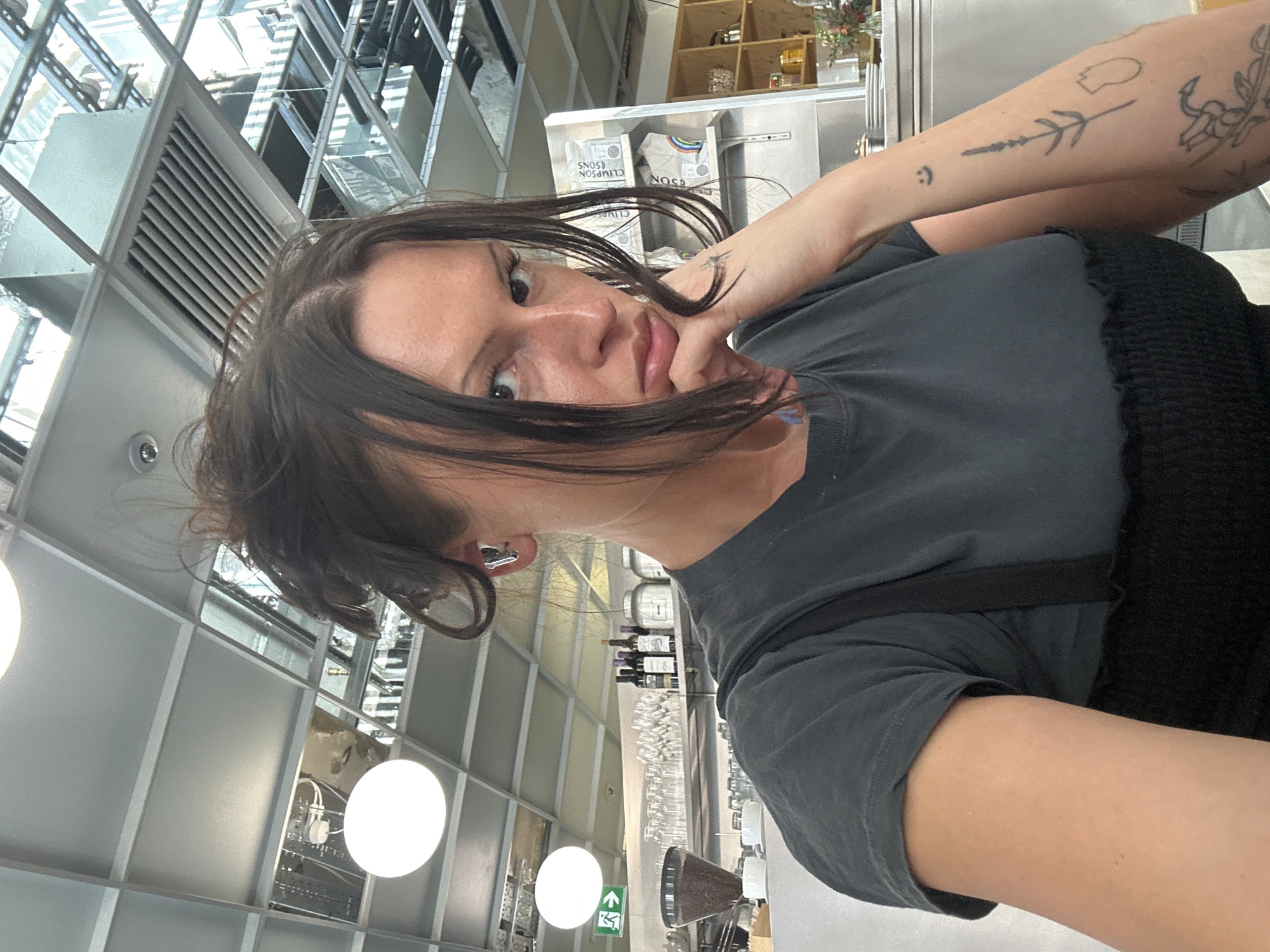 Woman takes selfie in flower-decorated London cafe