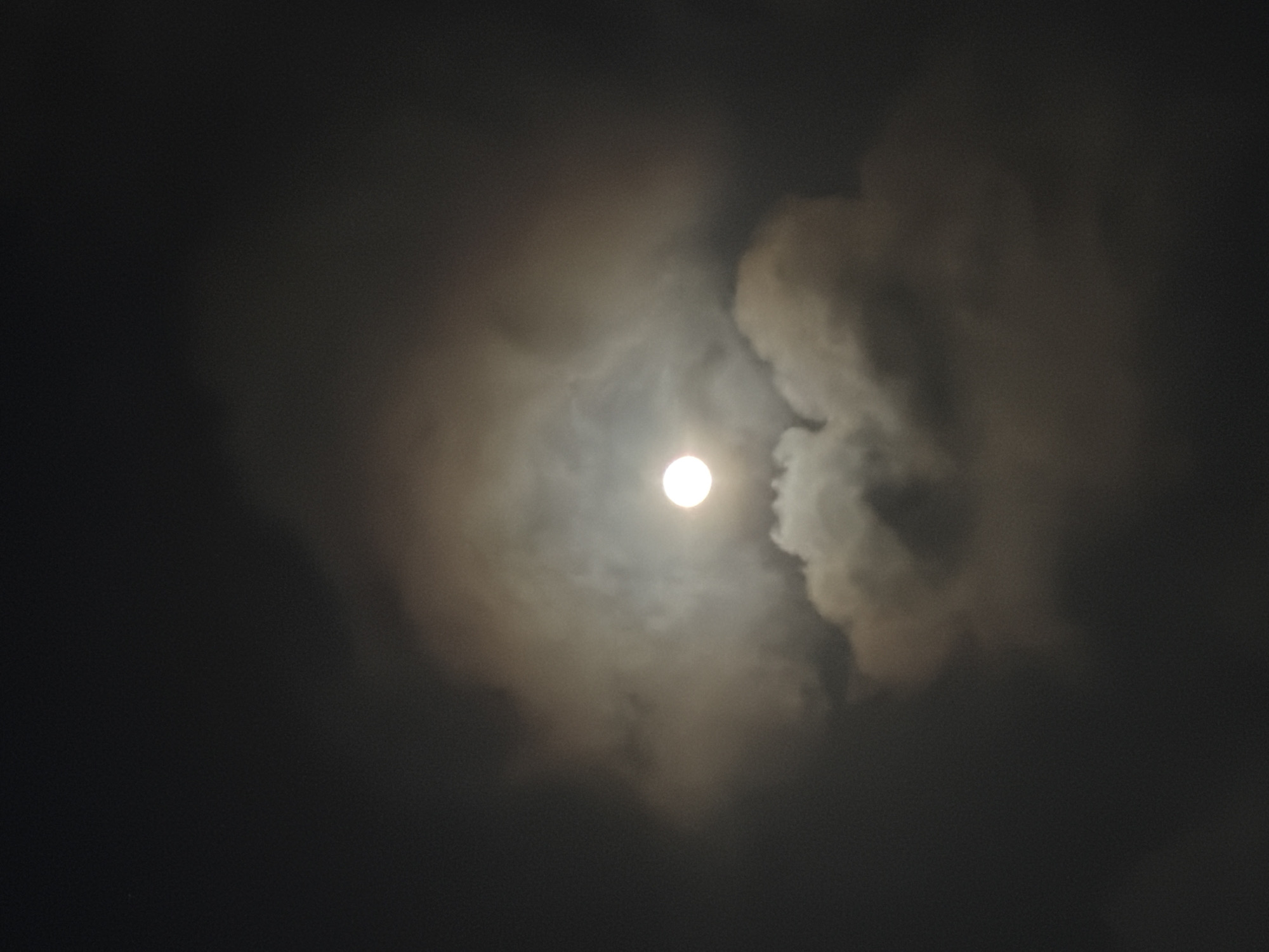 Full moon glimpsed through clouds over Igboefon, Nigeria
