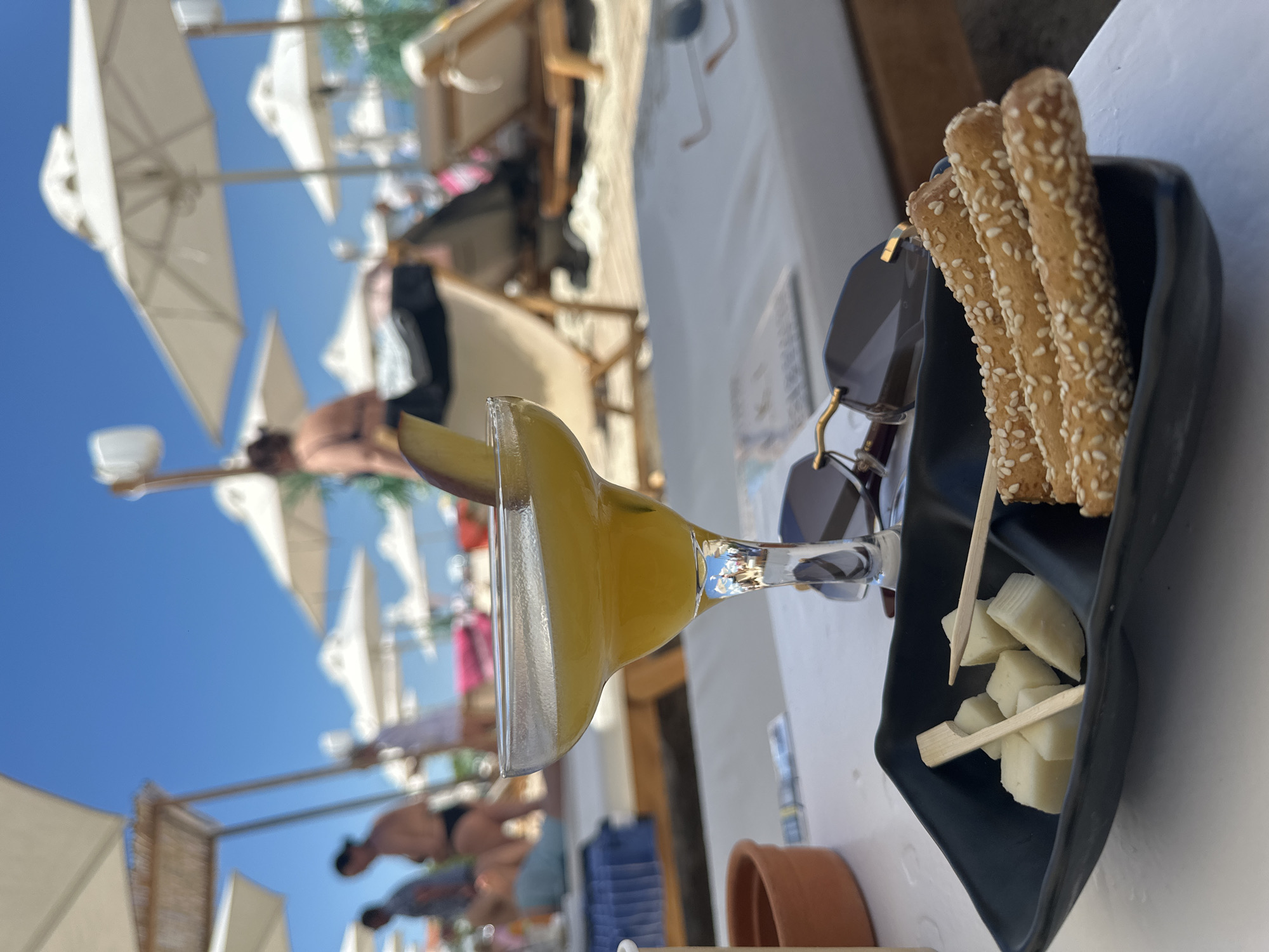 Beach club patrons enjoy drinks and sunbathing in Greece