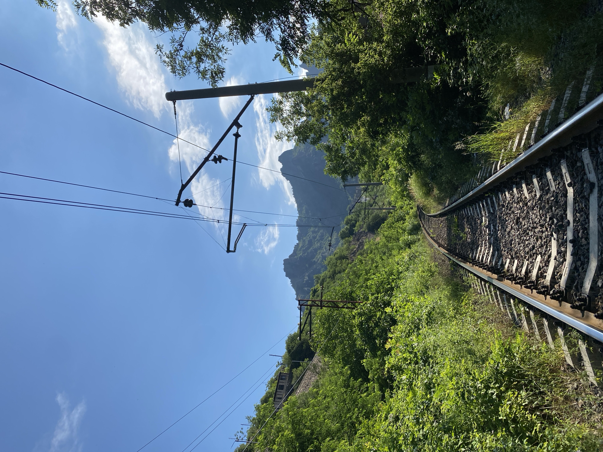 Electrified railway curves through green terrain in Alaverdi