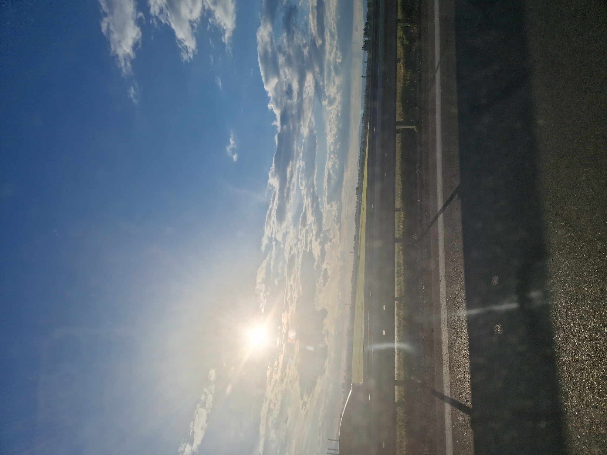 Sunny highway scene captured with bright skies and clouds